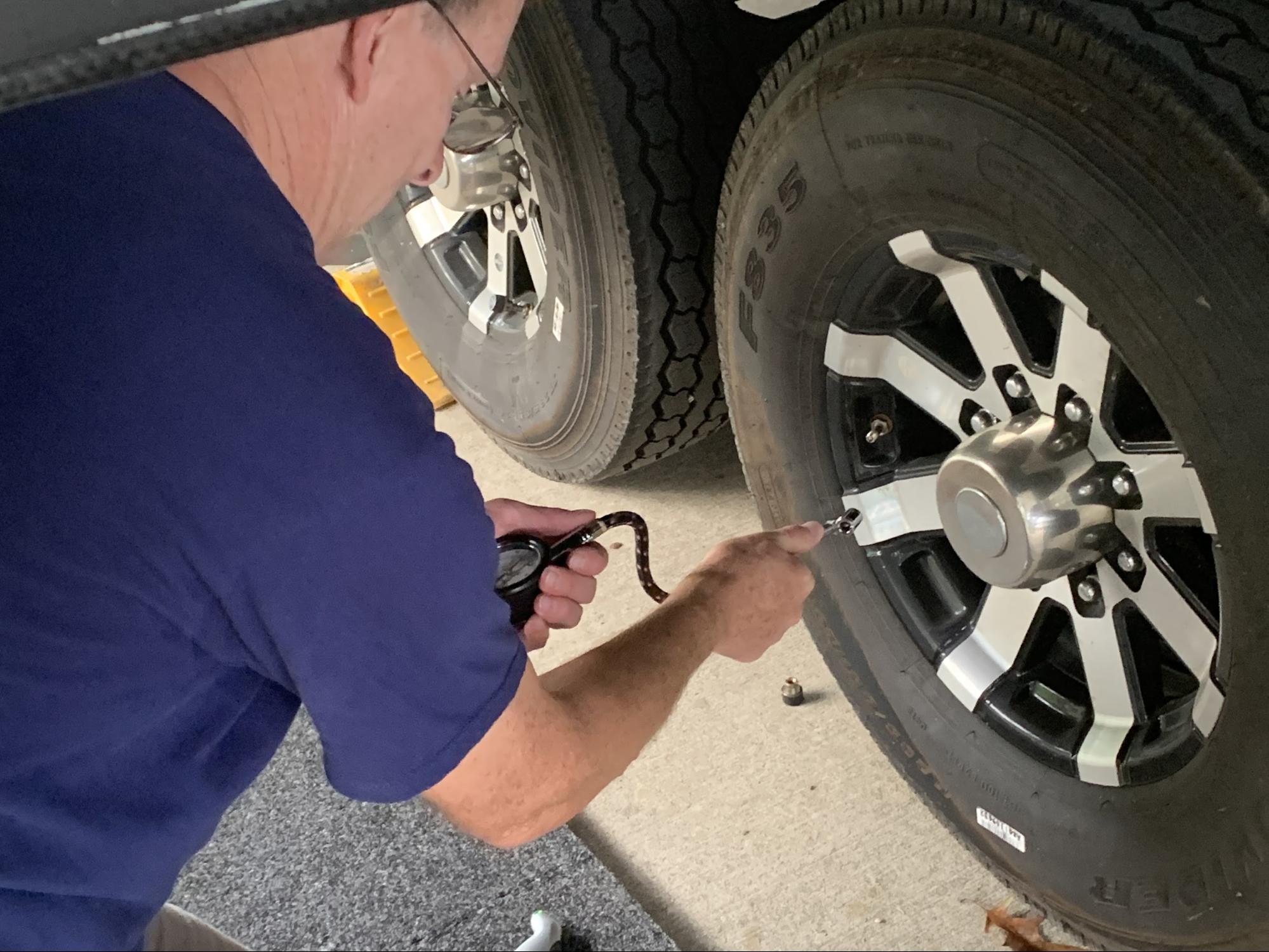 Tom Boswell showing how to check tire pressure on his RV.