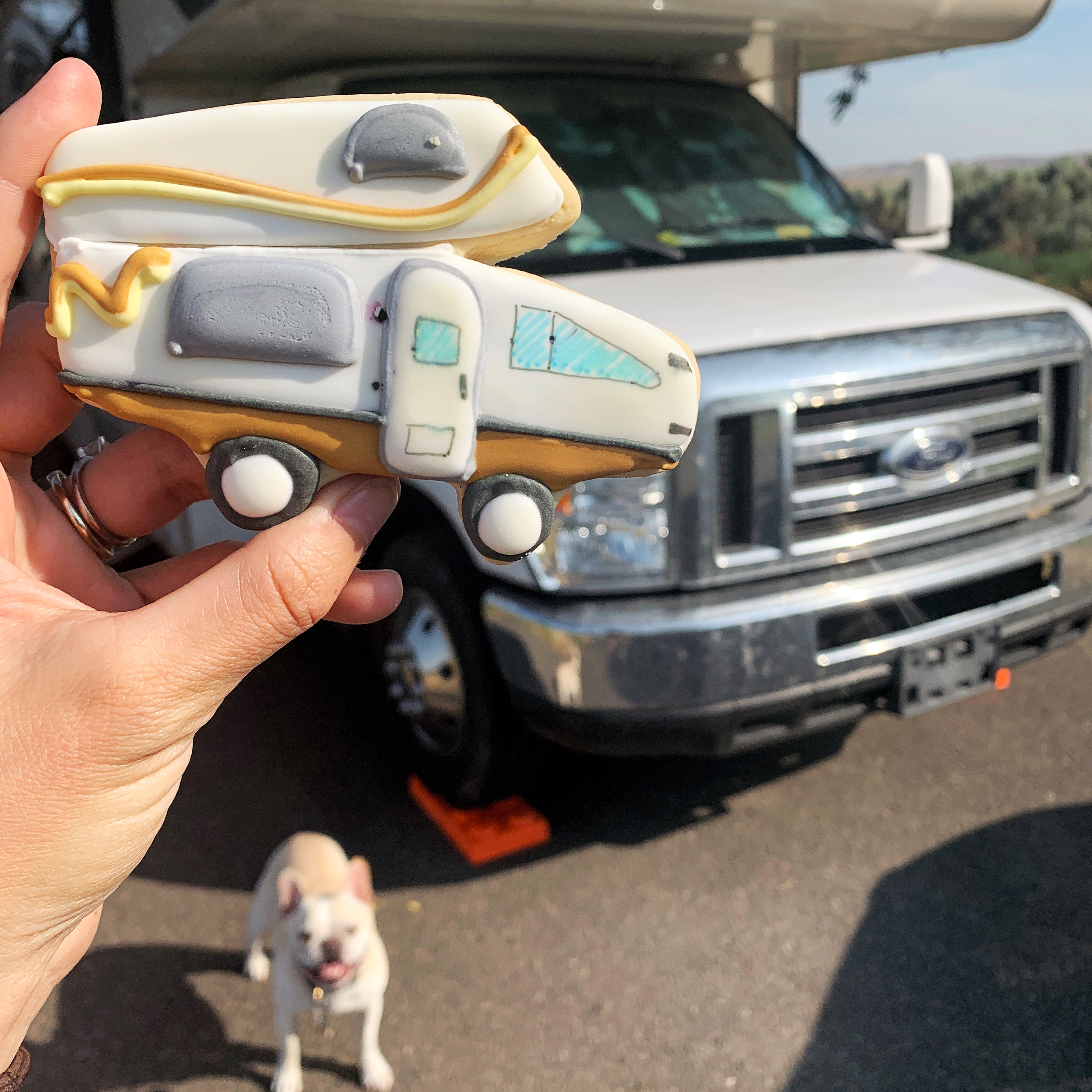 Sarah Hubbart's holds up a cookie in the shape of her Thor Motor Coach Chateau.