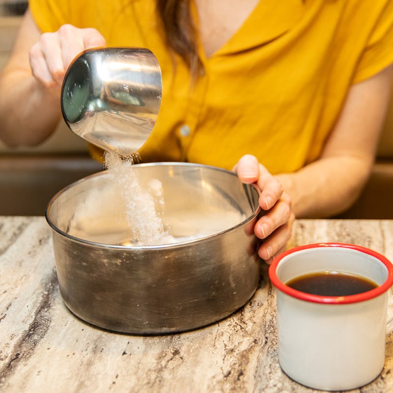 Measuring sugar into a saucepan.