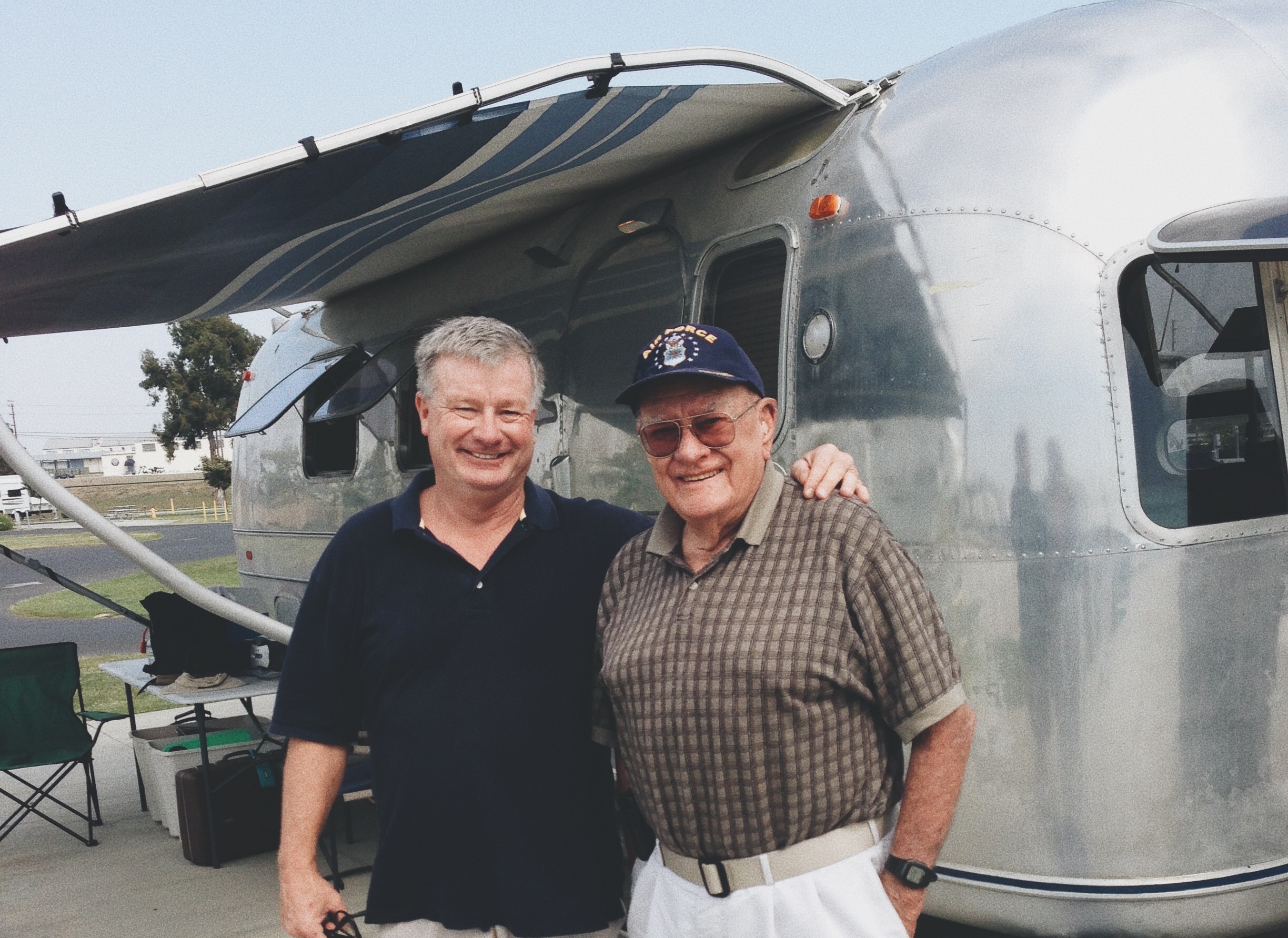 A middle aged man and his father posed for a photo in front of the family Airstream. 