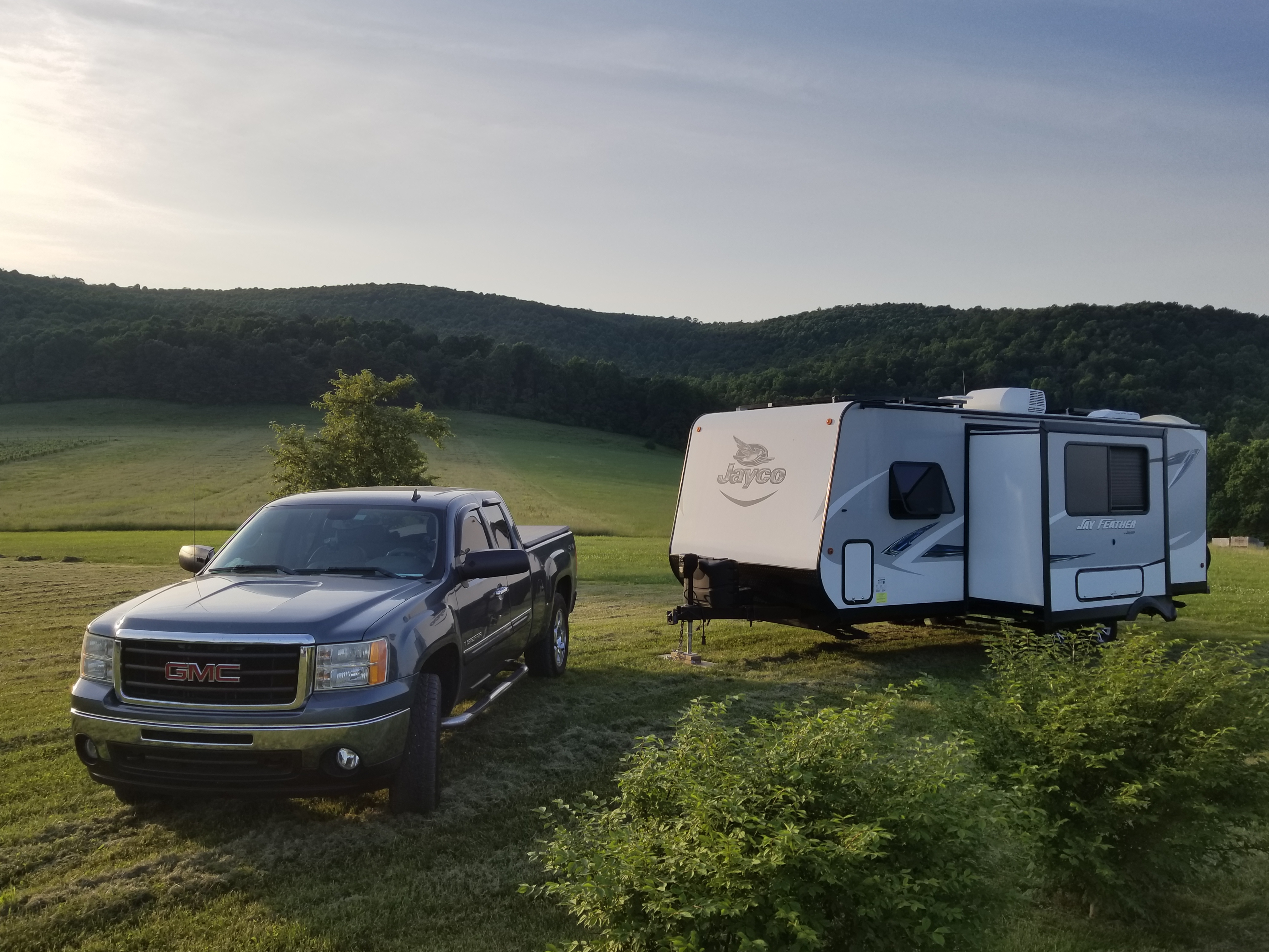 Ben and Christina McMillan's RV parked in a grassy field next to their truck