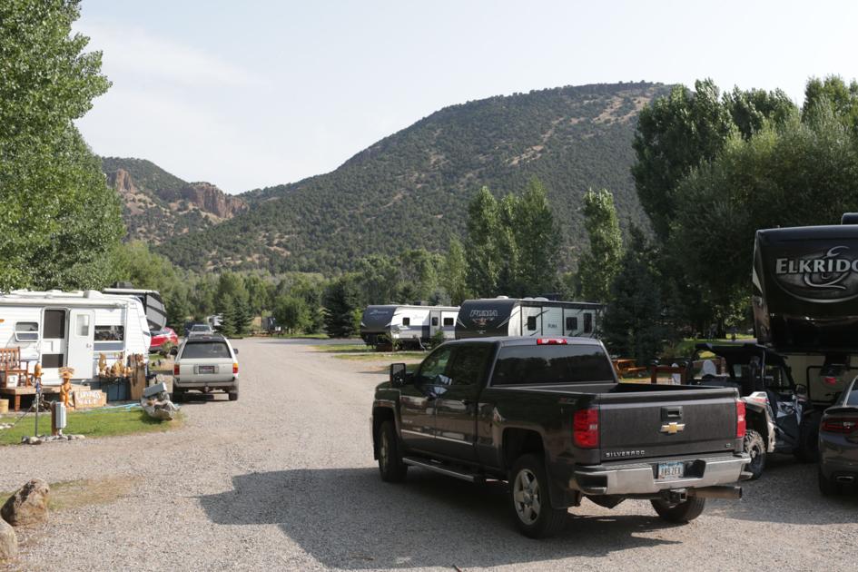 A truck driving down a road with RV's parked along the side