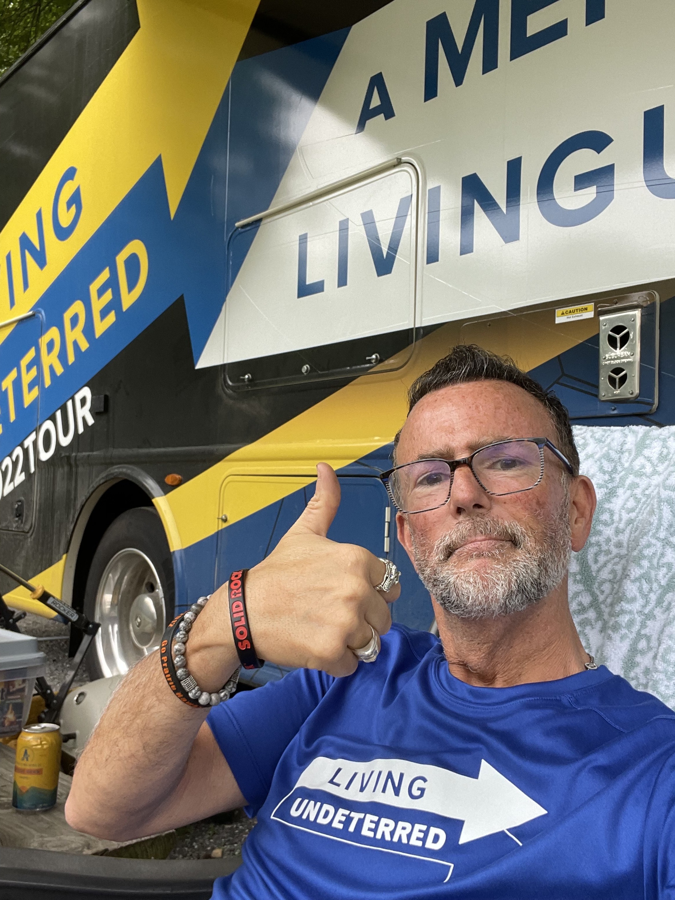 Jeff Johnston sitting in front of his Class A Motorhome with a thumbs up