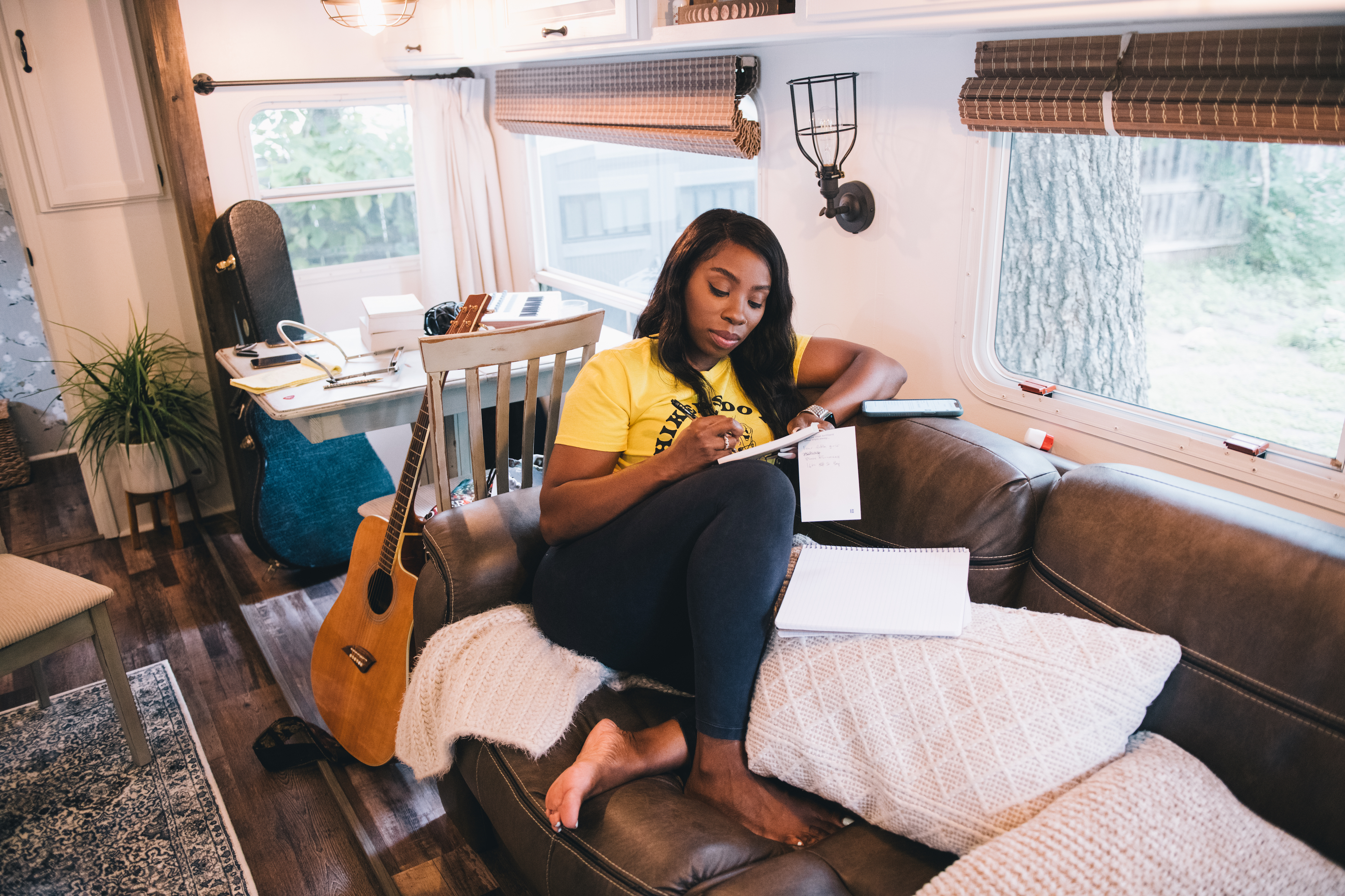 Jessy writes in a notebook on the couch inside her Keystone Couger