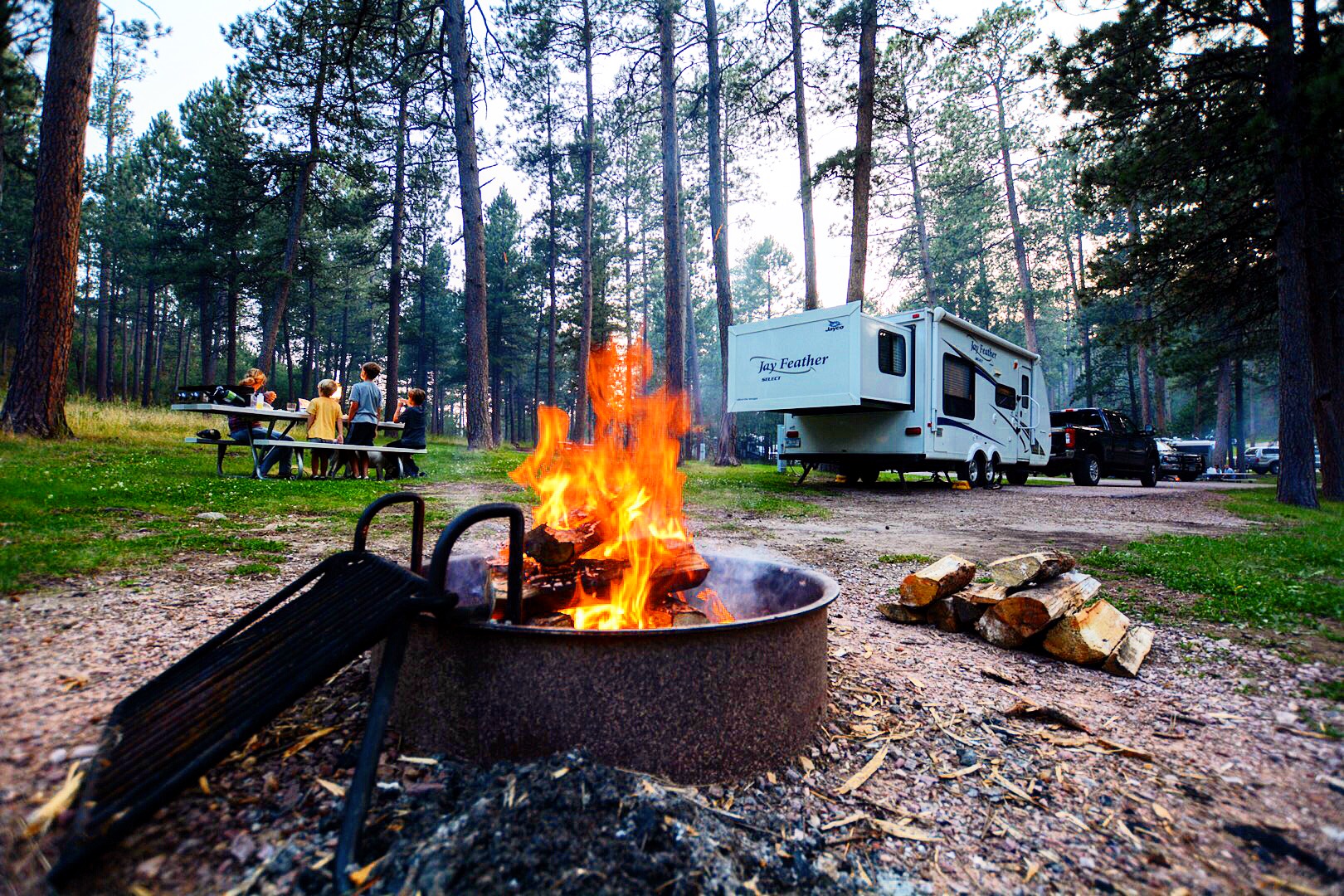 A roaring fire in a pit at an RV campground. 
