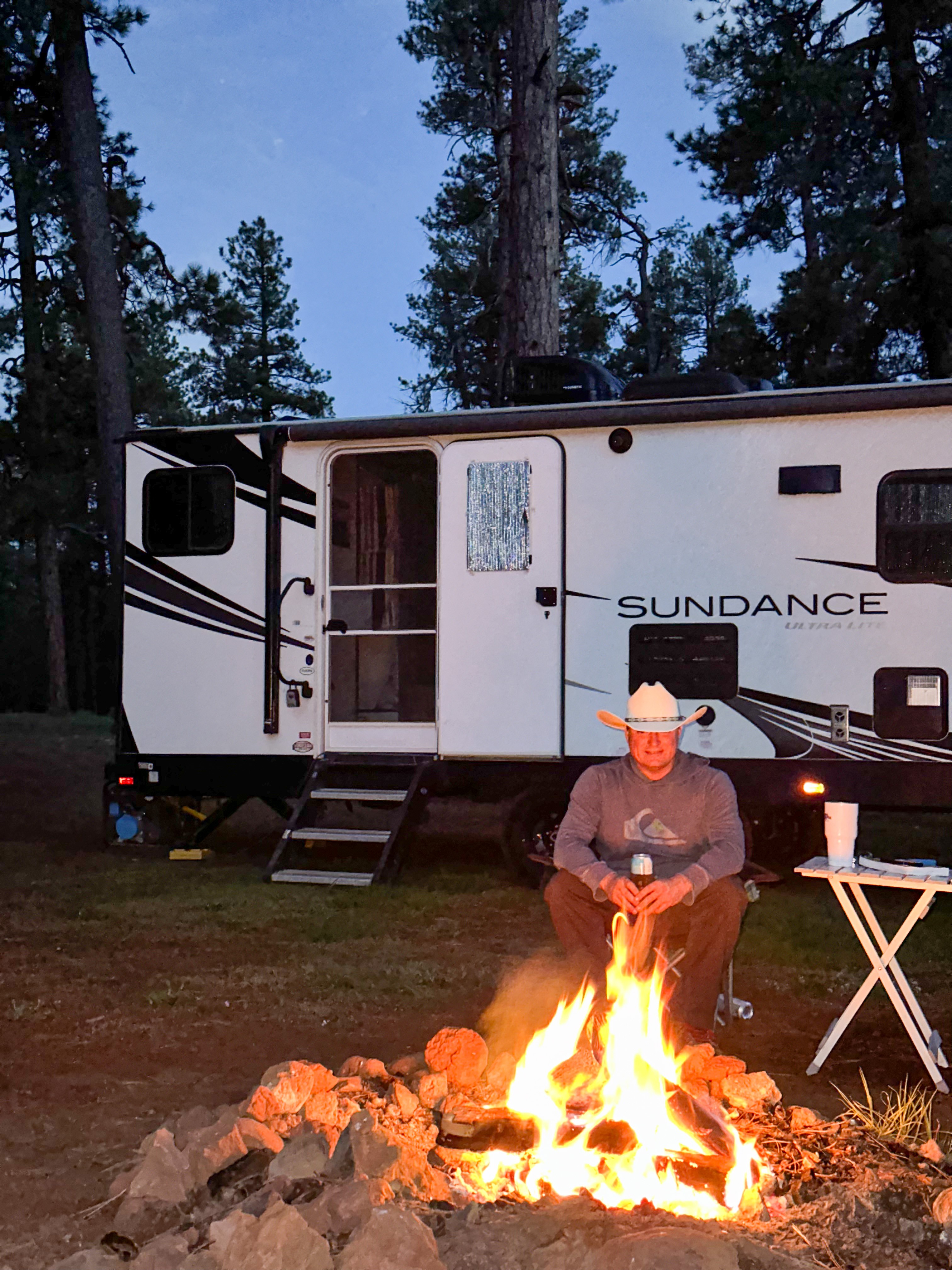 Jeff Poe enjoying a campfire in front of his Heartland Sundance RV