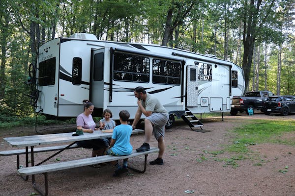 STEVE & KAYLEE TECHAU's family at a picnic table in front of their Keystone Cougar