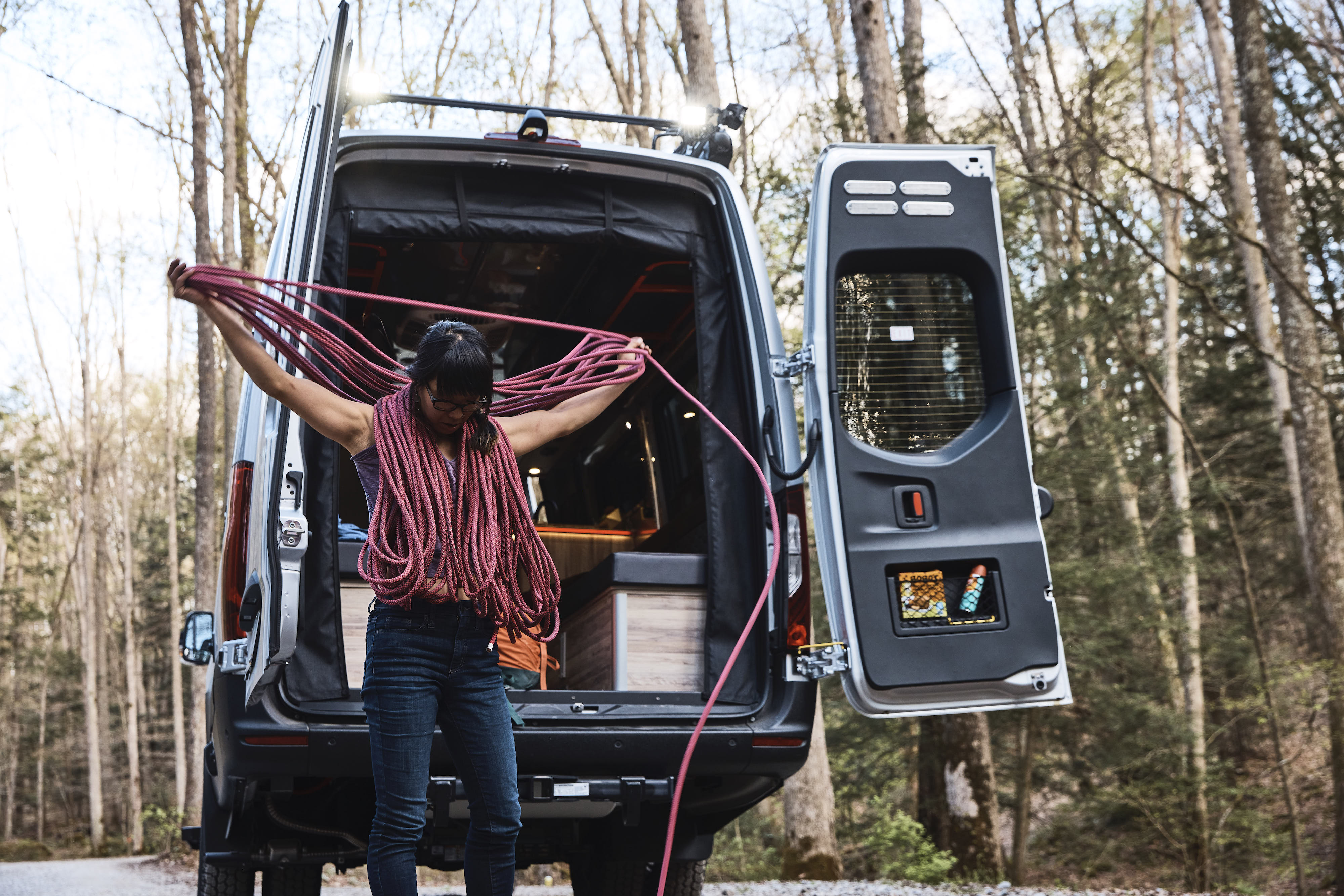 Kathy Karlo prepping climbing gear outside of an Airstream camper van
