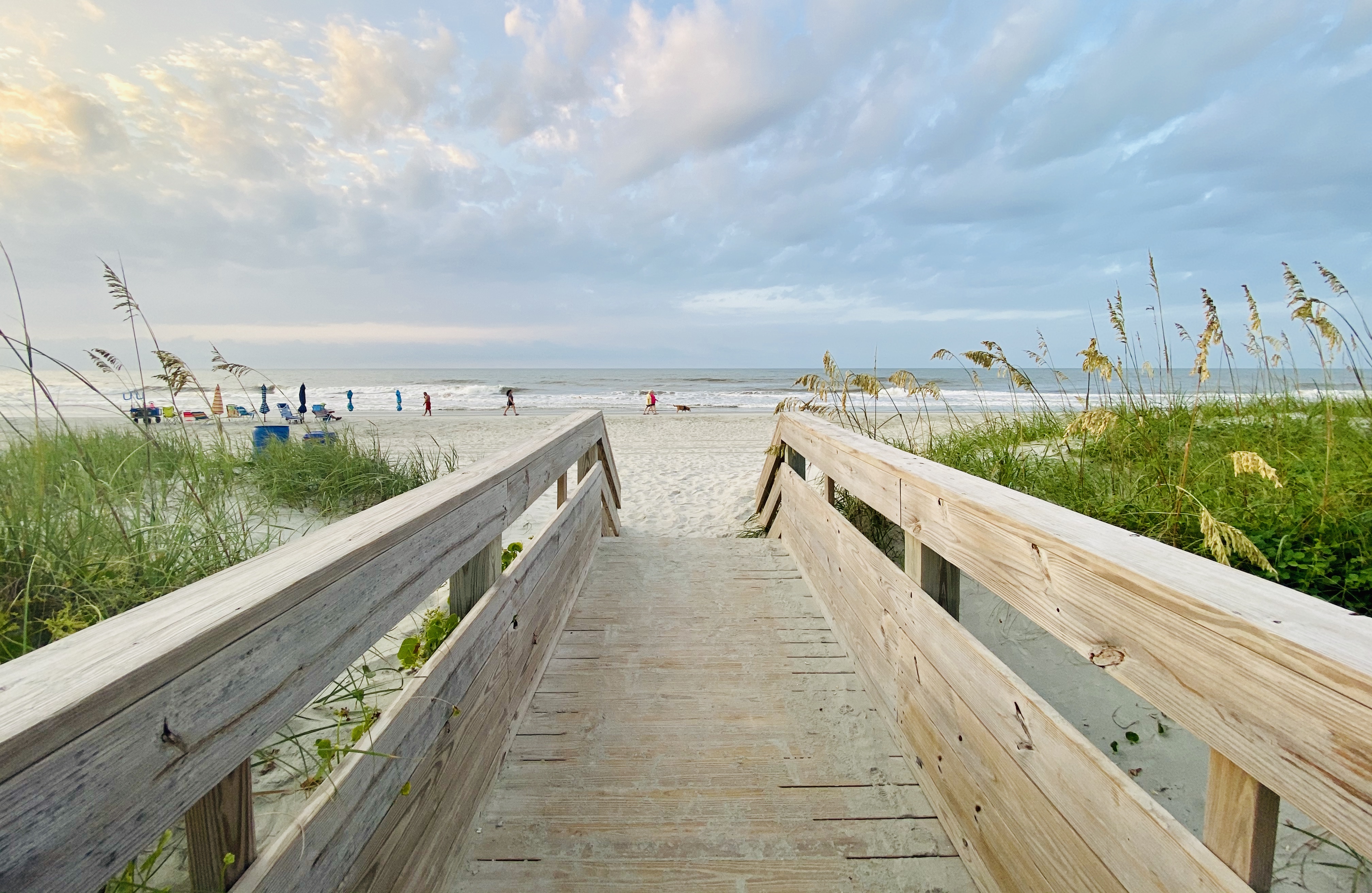 A photo of a boardwalk opening up to the beach.