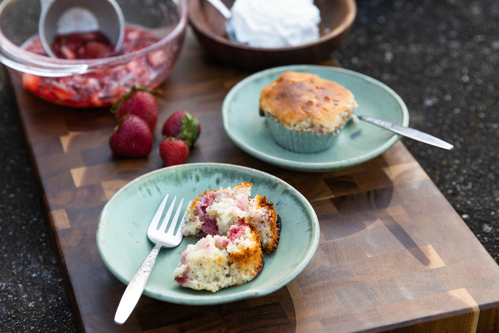 A strawberry corn muffin broken apart on a plate.
