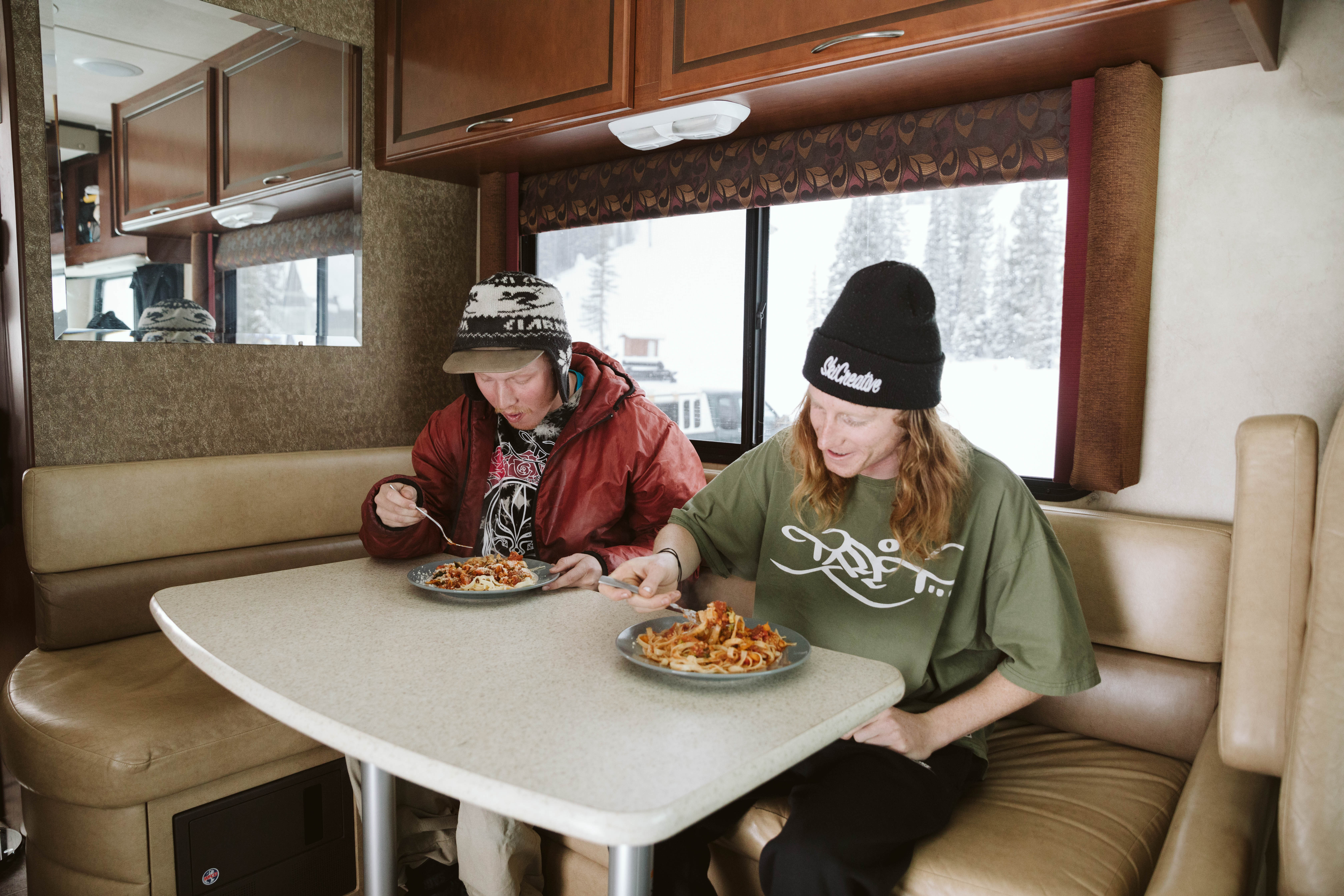 Ryan and his friend eating homemade veggie spaghetti in the RV.