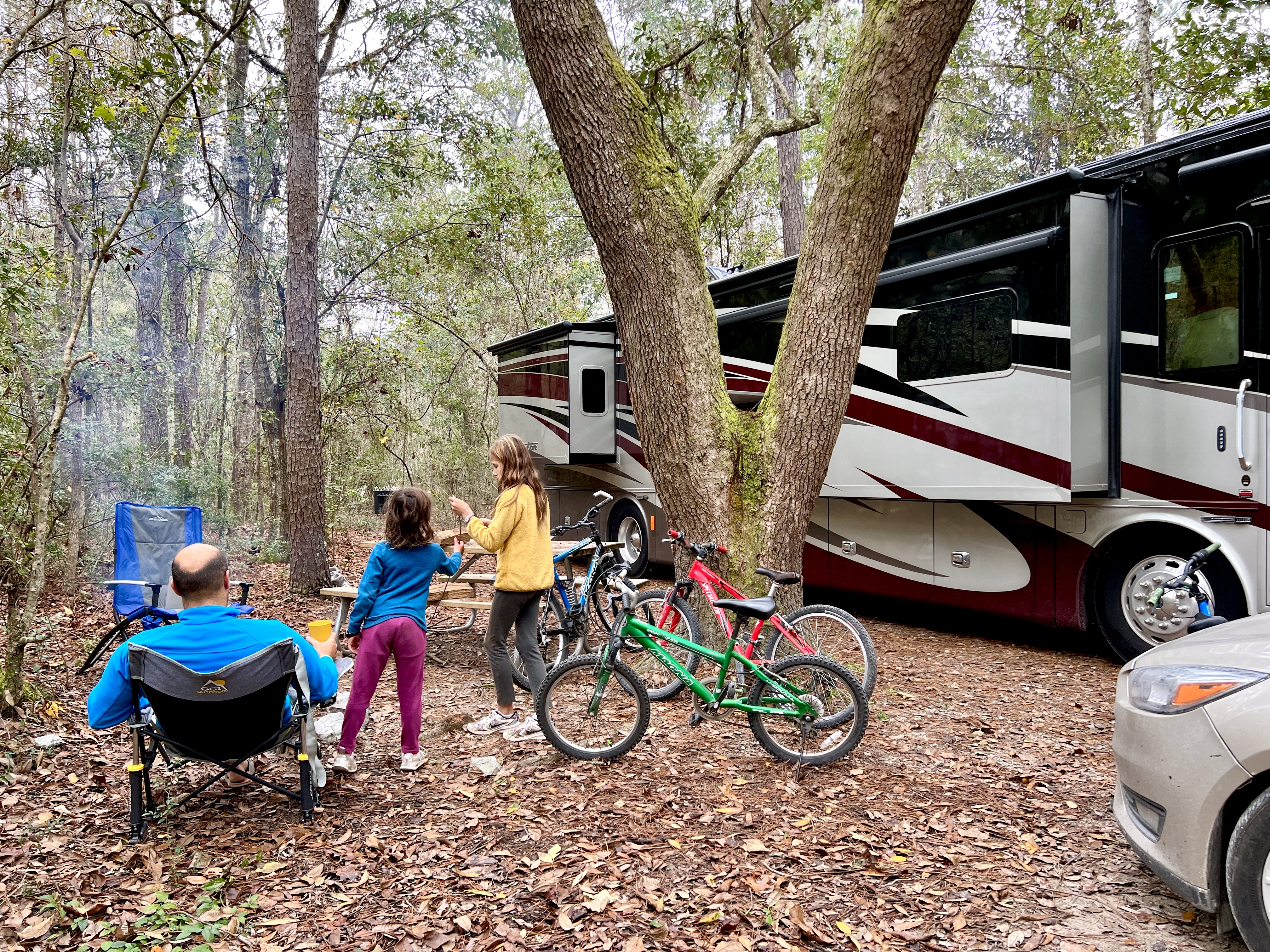 LAURA GEORGIEFF's family playing and sitting outside of their Tiffin Phaeton RV