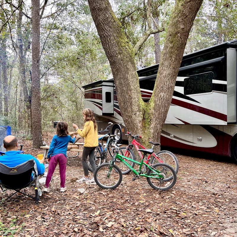 LAURA GEORGIEFF's family playing and sitting outside of their Tiffin Phaeton RV