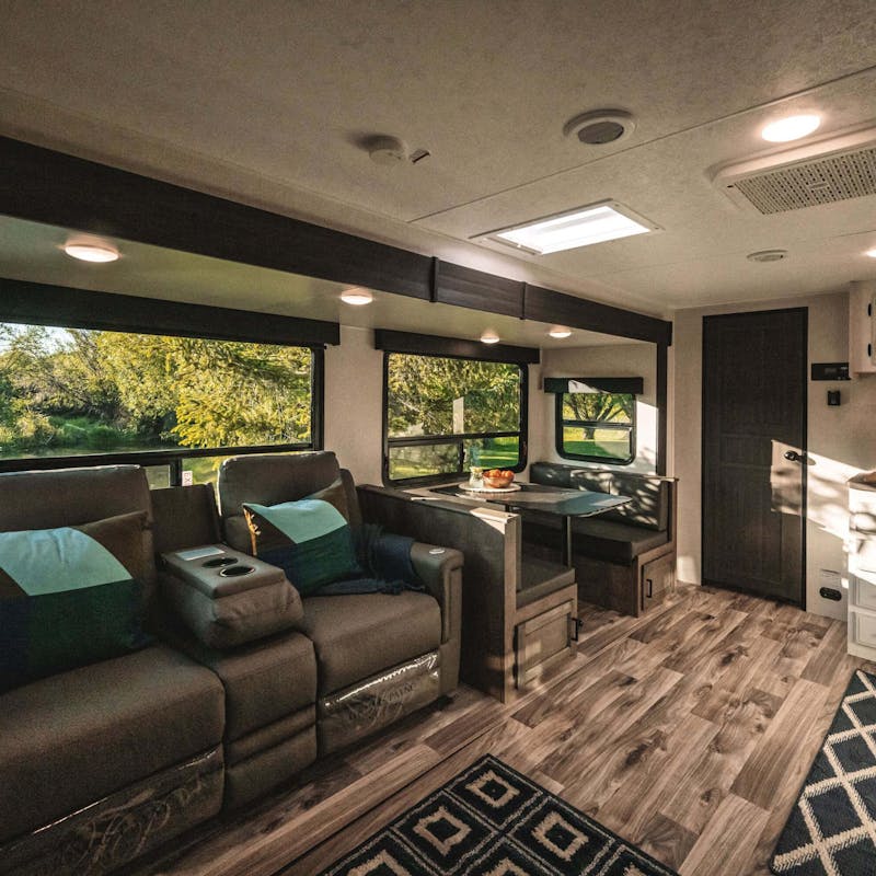The living room, dining room, and kitchen inside a Venture RV.