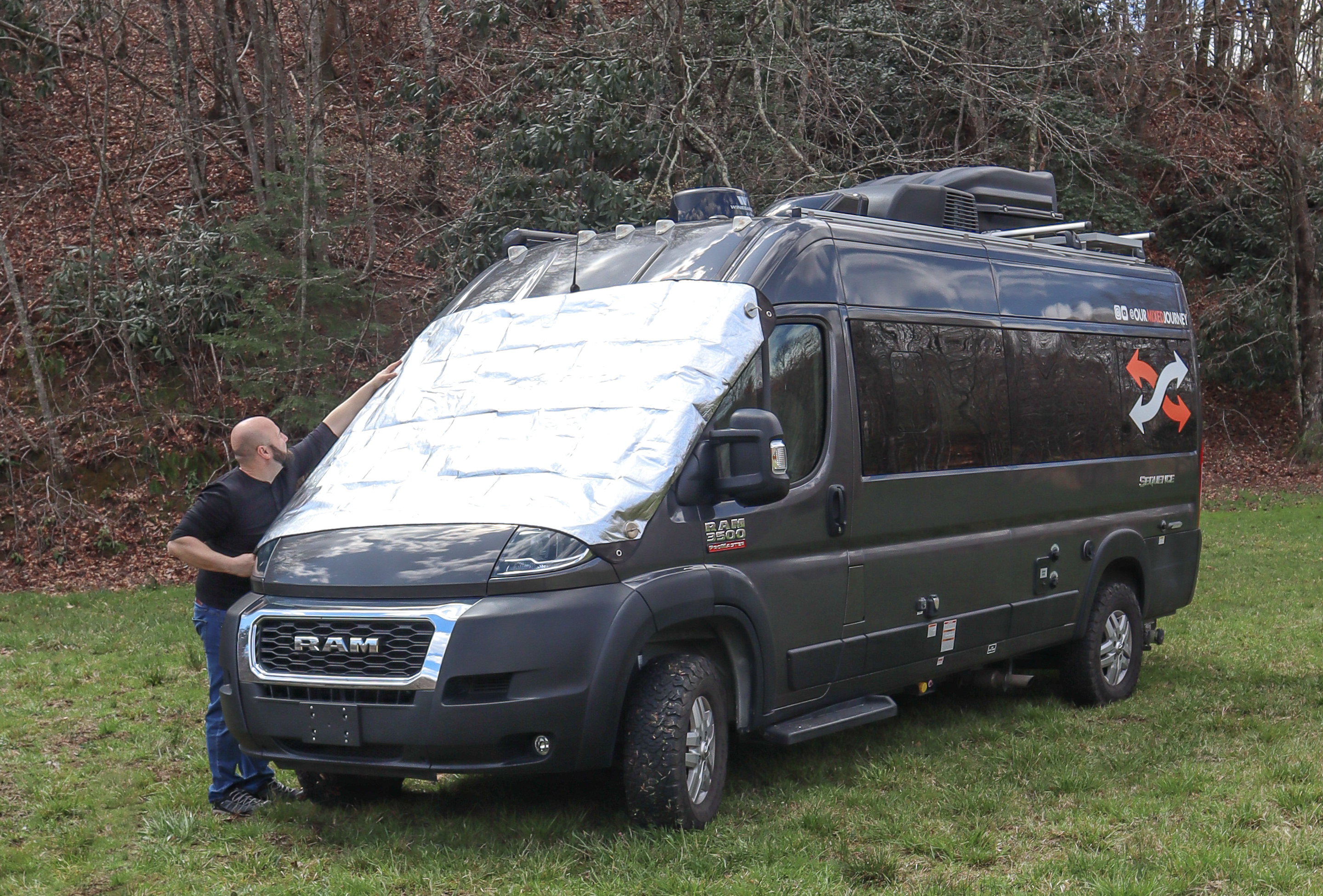 Gabe putting window insulation on the hood of his RV