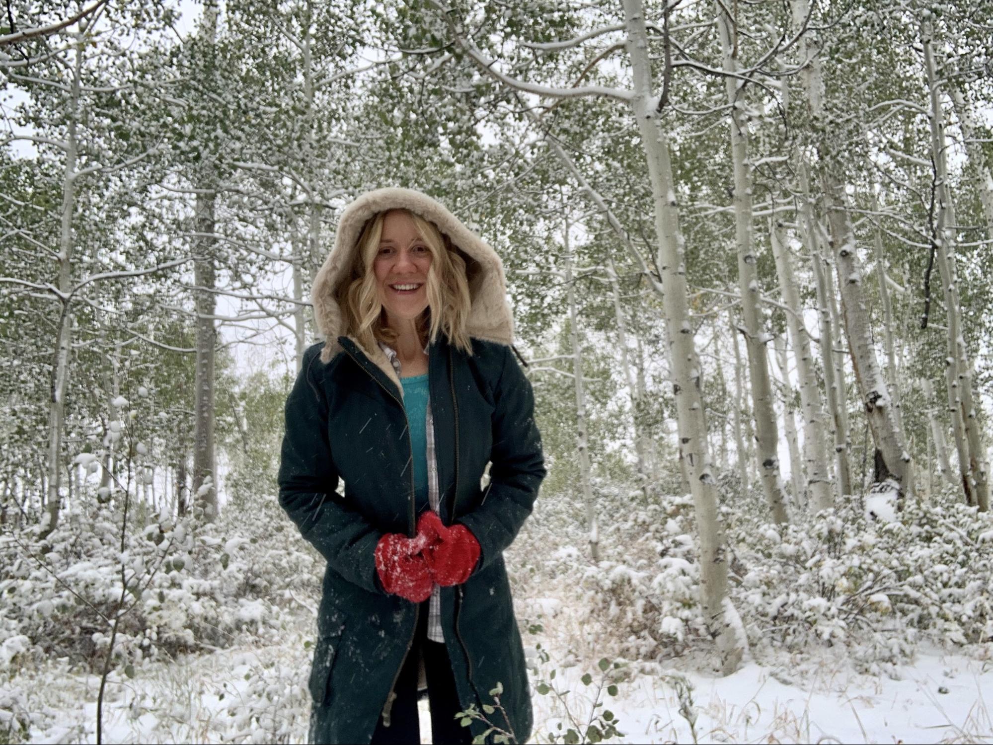 A woman smiles in the snow.