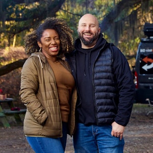Gabe and Rocio Rivero smiling for a portrait in front of their Thor Motor Coach Sequence Class B Camper Van