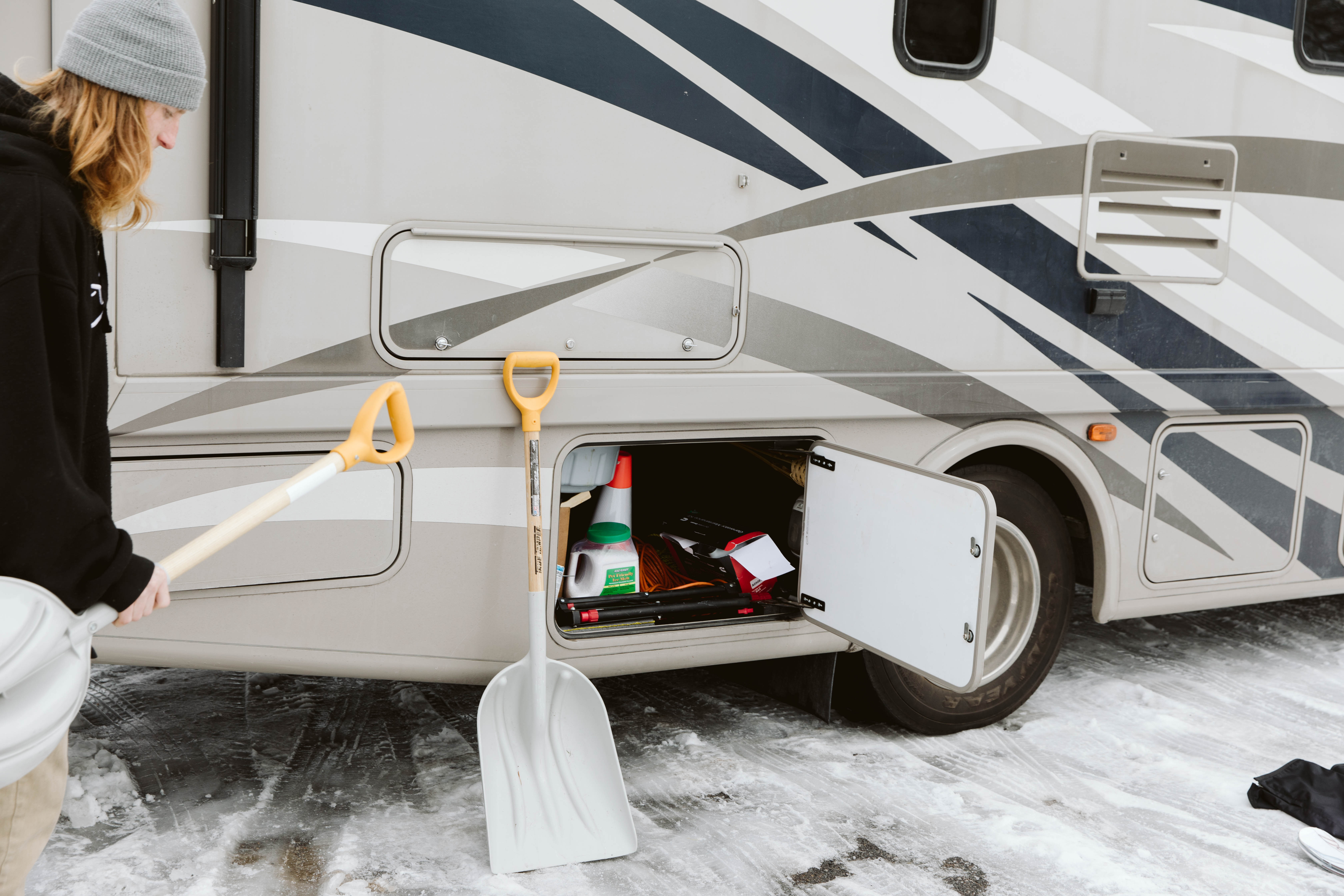 Storing snow shovels in an exterior RV cubby. 