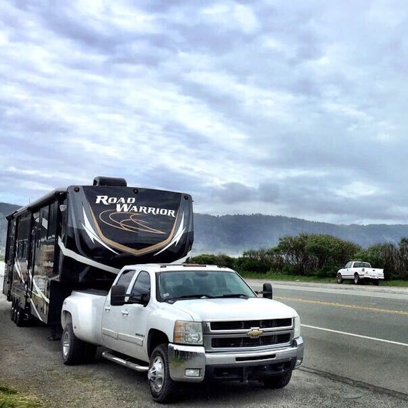 Eric Hannan's Heartland Road Warrior fifth wheel RV parked off the road near an ocean.