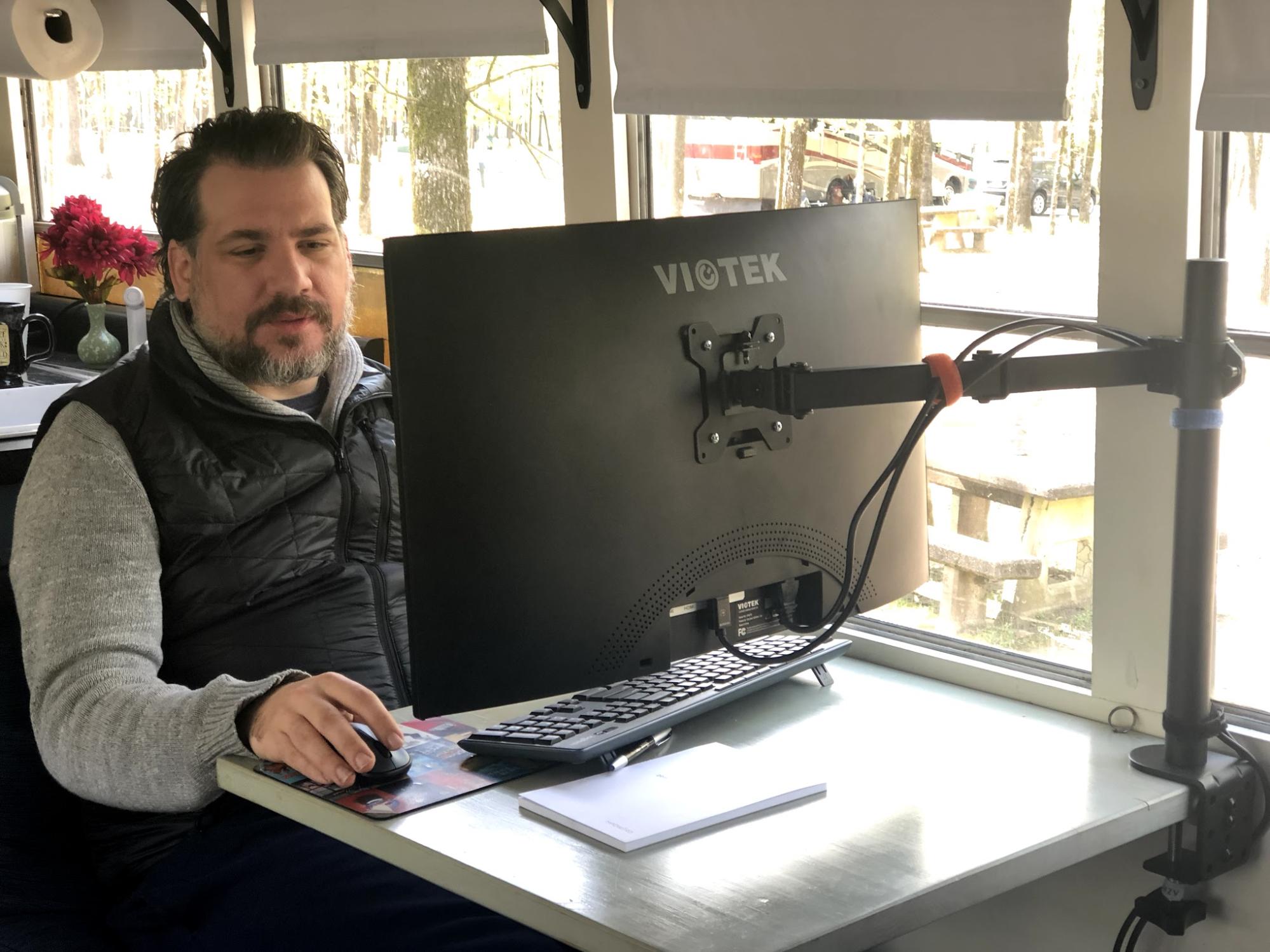 Abby Epperson's husband doing work at a computer inside their Heartland Pioneer.
