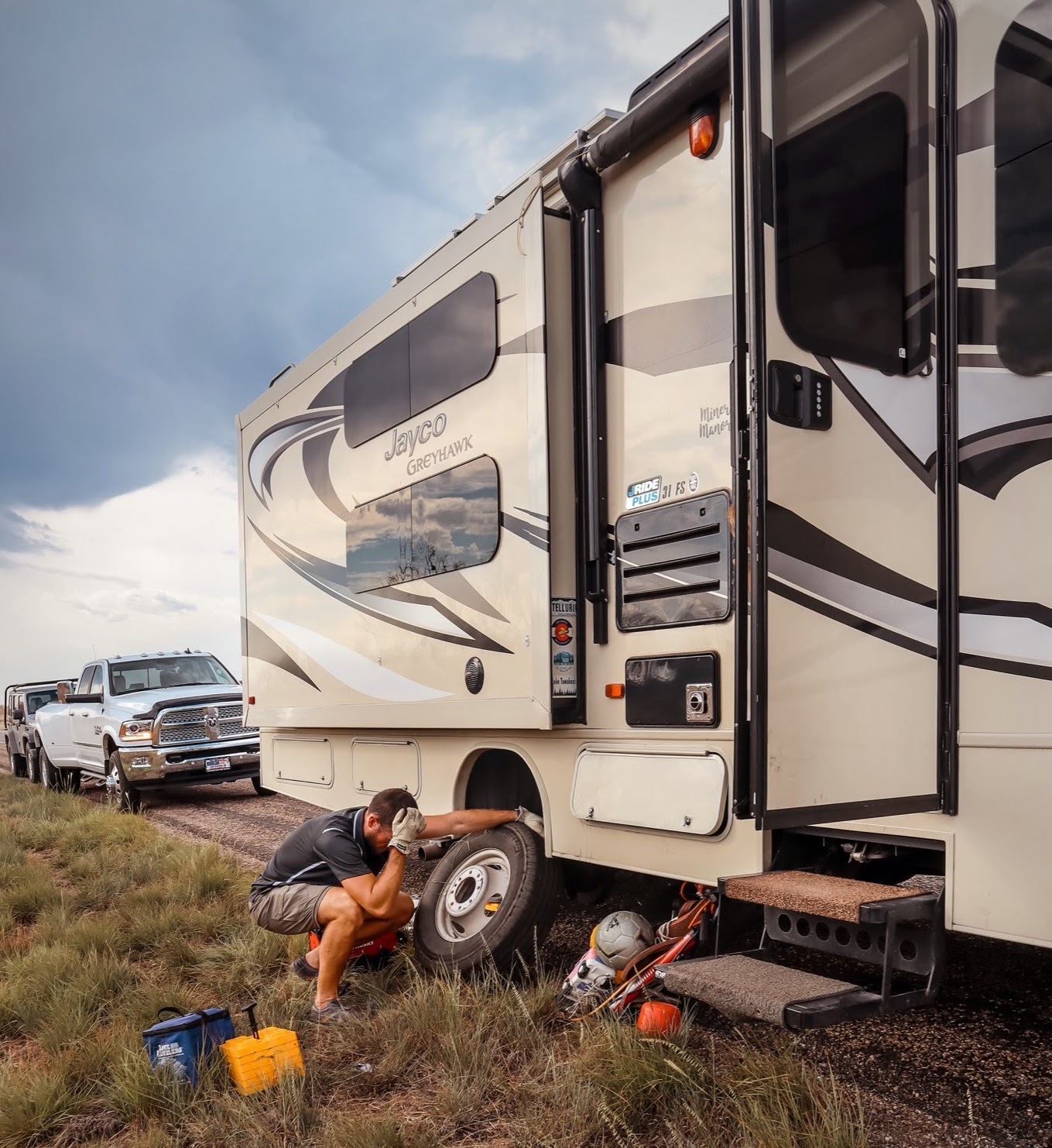 Holly Miner's husband changes a tire on their Jayco Greyhawk
