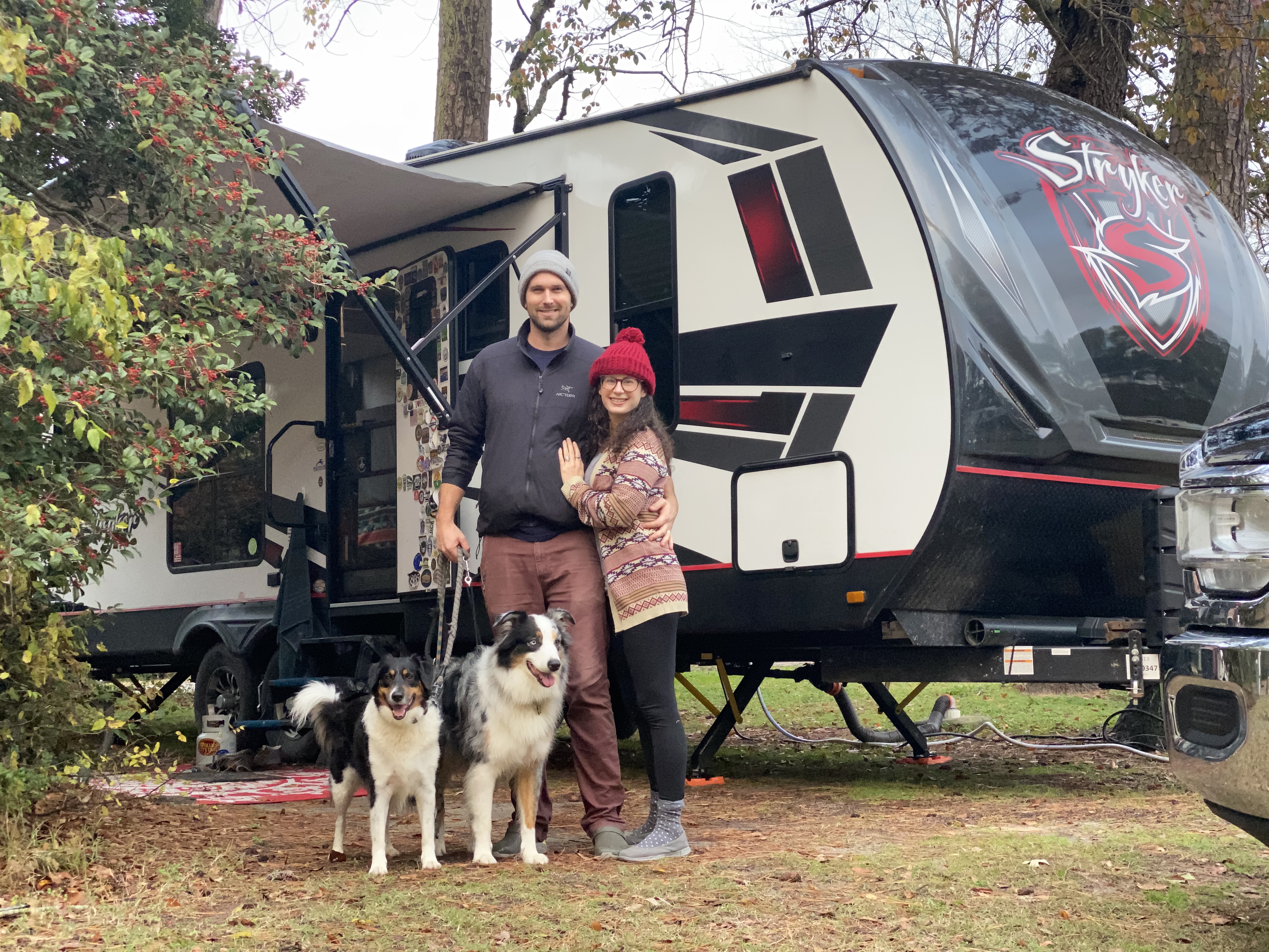 Amy Rekart and her husband pose with their two dogs in front of their Cruiser Stryker toy hauler. 