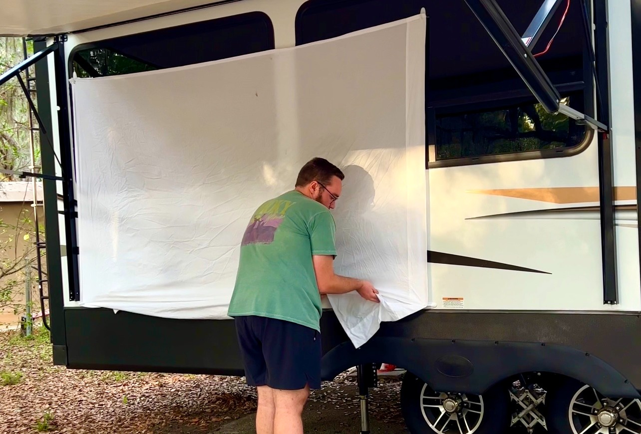 Bailey Damberg's setting up a projector screen outside of his Dutchmen Astoria 