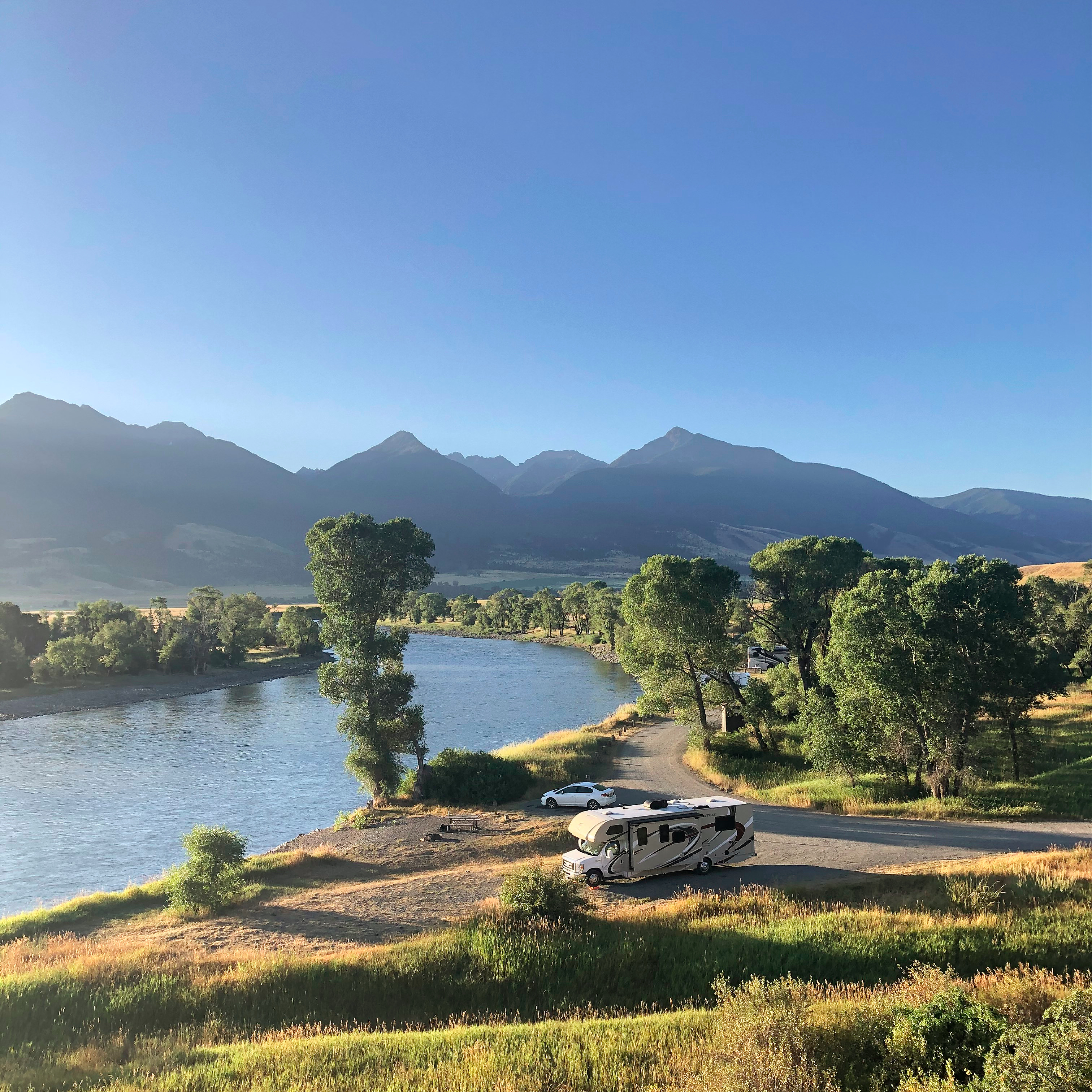 Sarah Hubbart's Thor Motor Coach Chateau parked by a lake with mountains in view. 