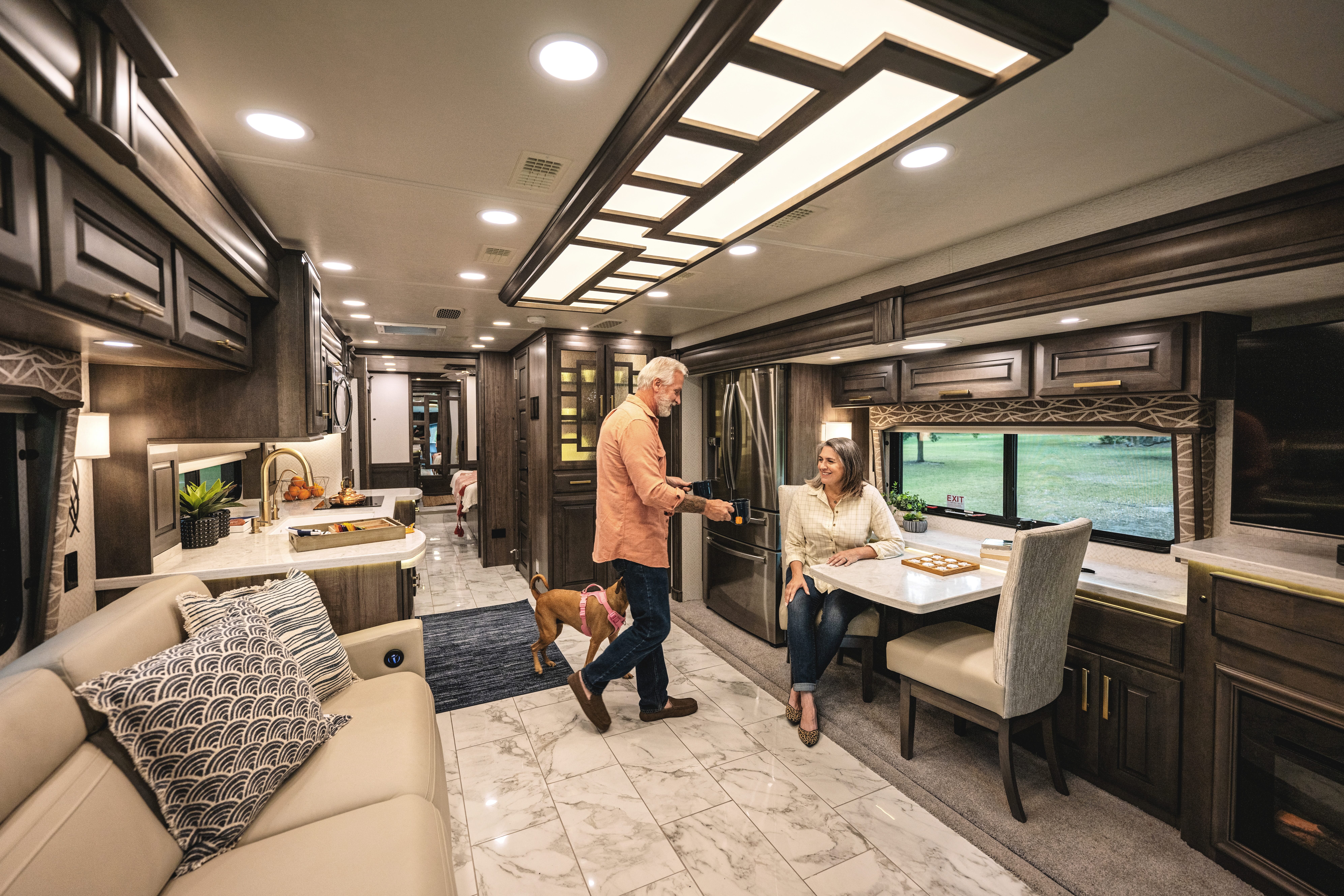 A couple sips tea inside a Class A Entegra Cornerstone Motorhome.