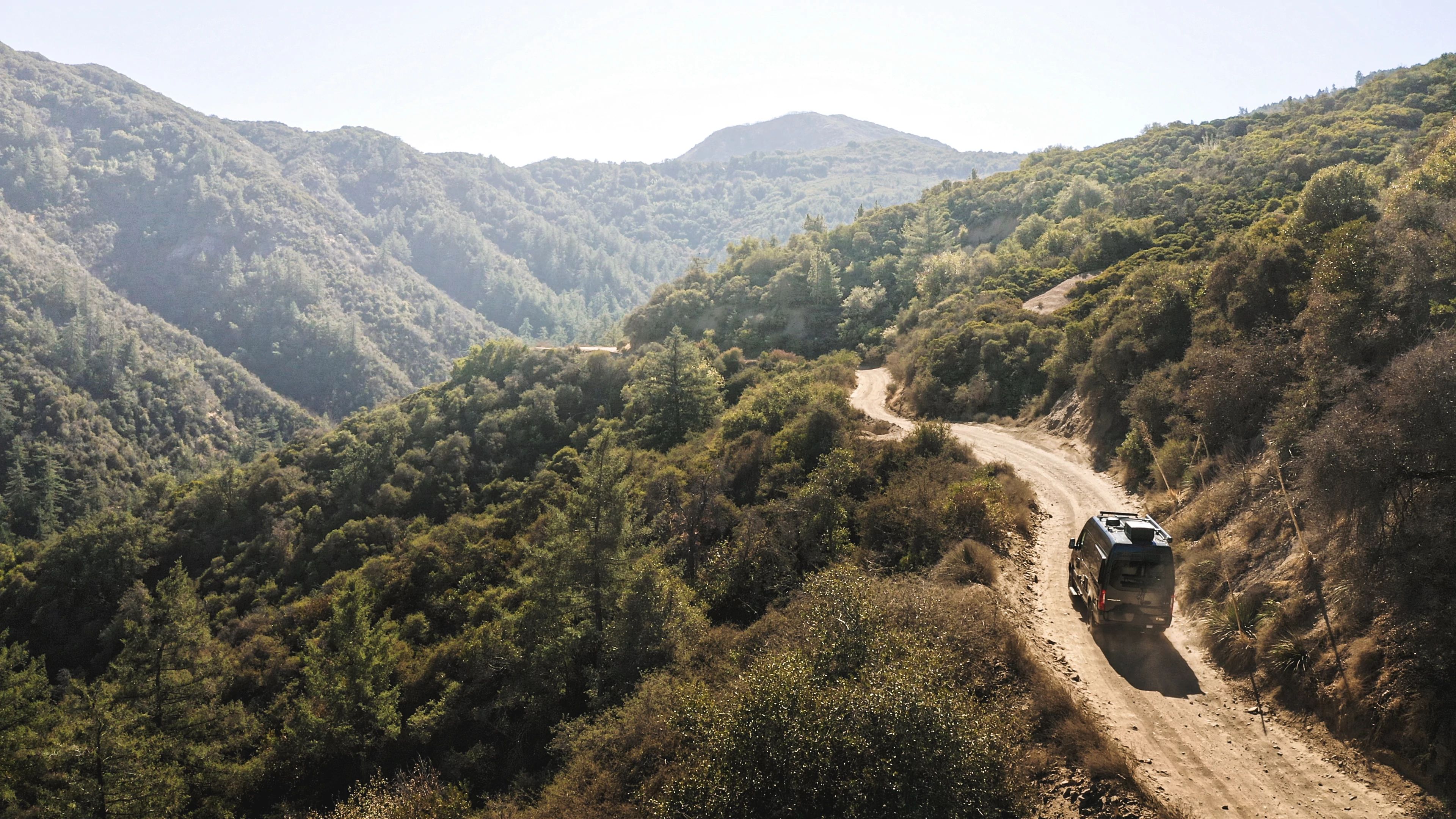 Sarah Glover driving a Class B Camper van through the California mountains 