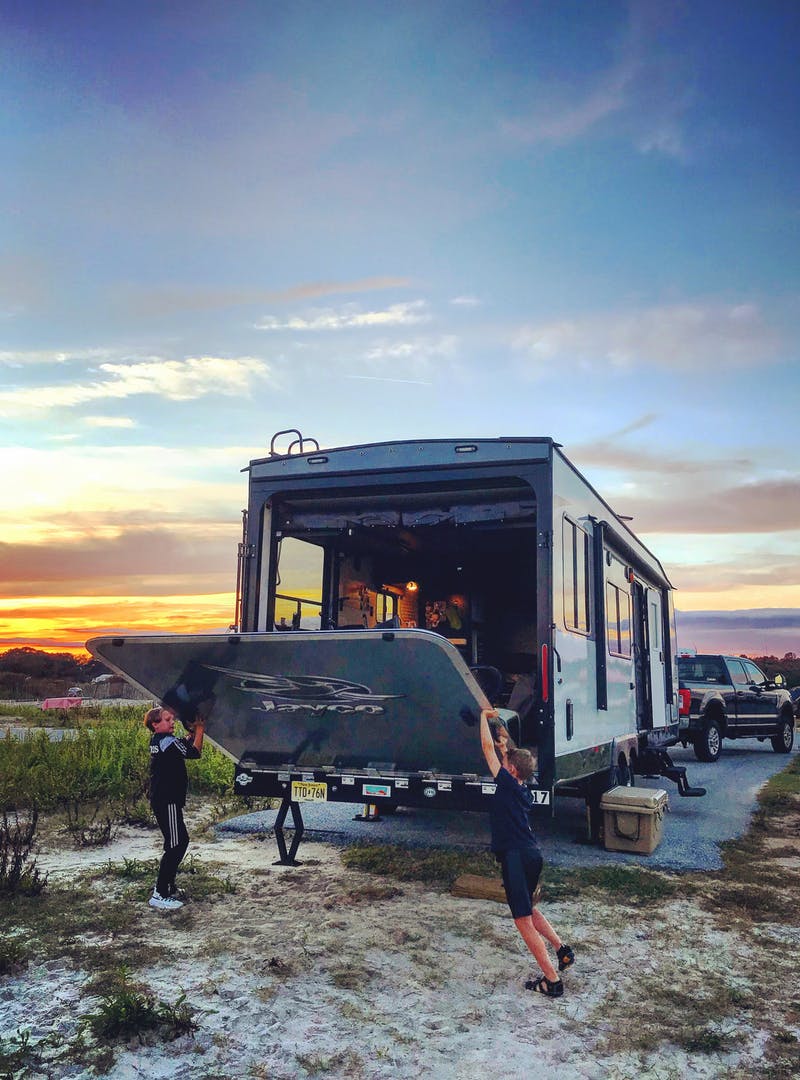 A toy hauler boondocks during sunset.