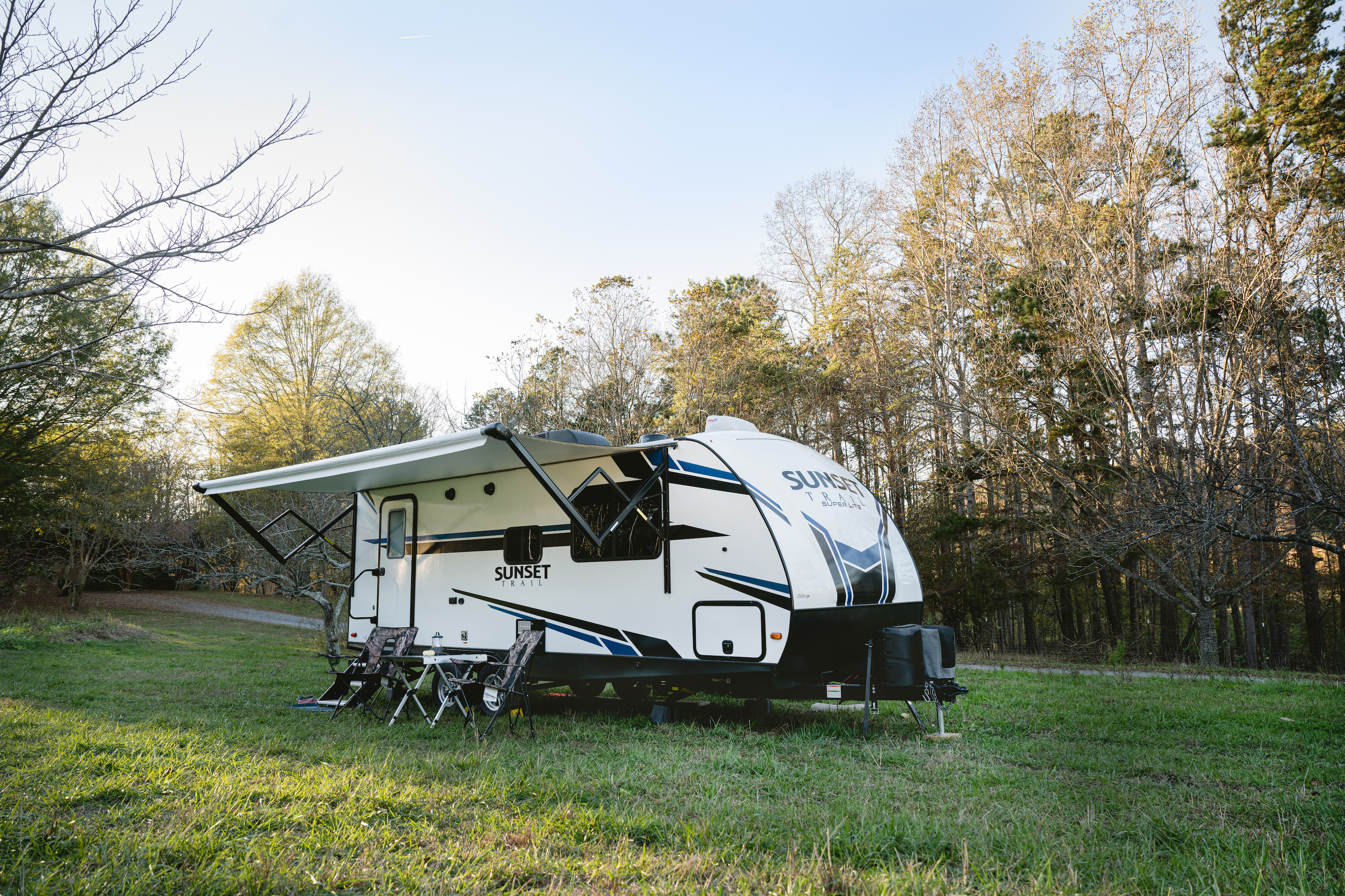 Todd and Marcia Schabel's Crossroads Sunset Trail parked in a grassy field surrounded by trees.