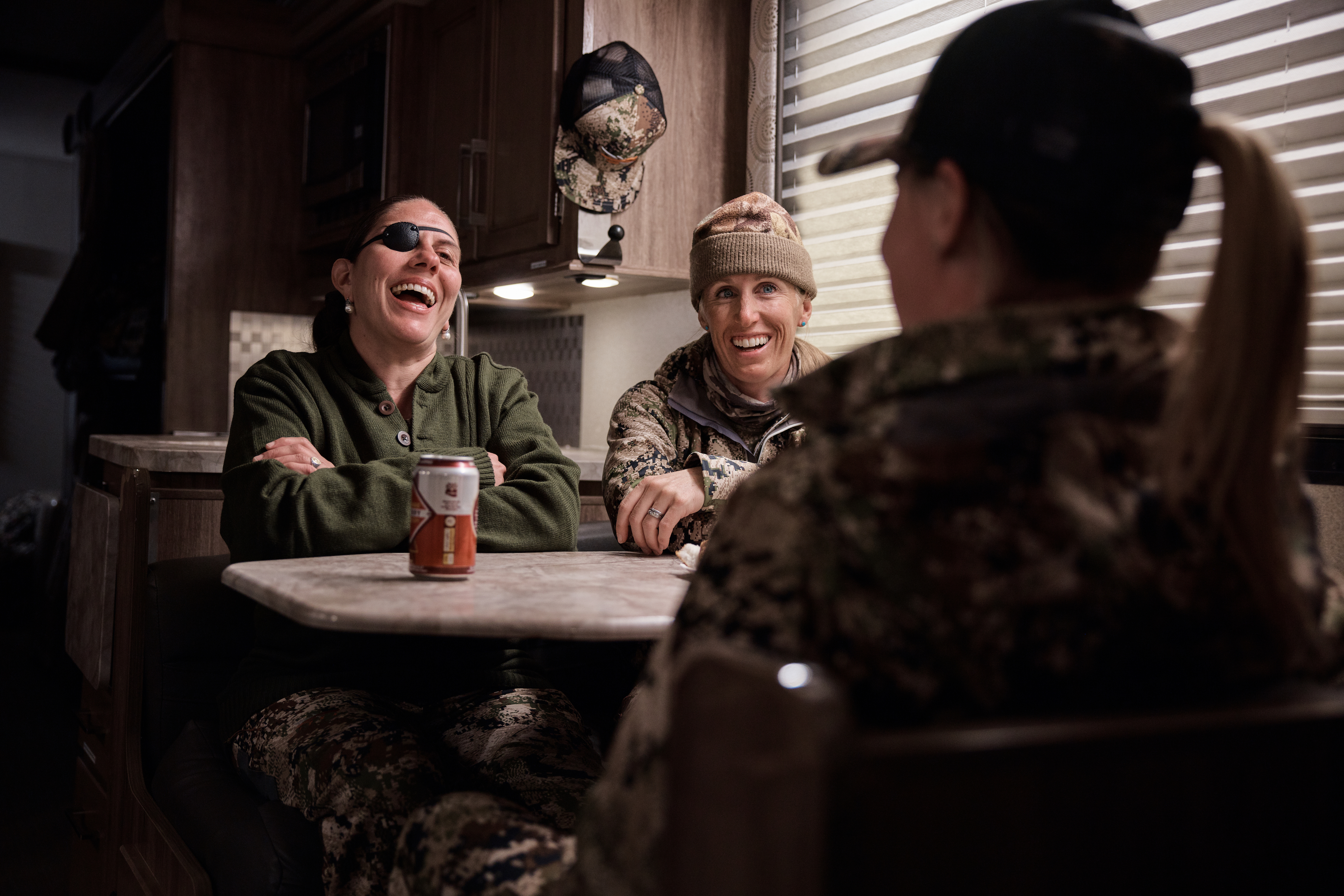 A group of veteran women chatting inside a class c RV after a hunt