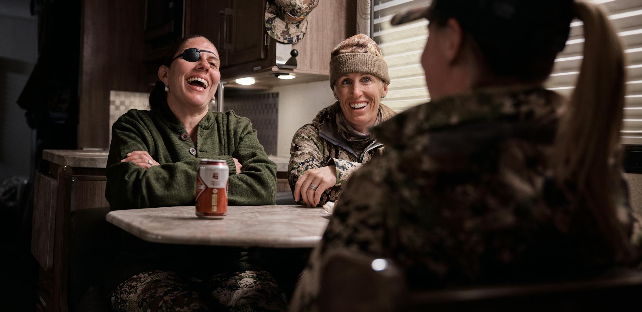 A group of veteran women chatting inside a class c RV after a hunt