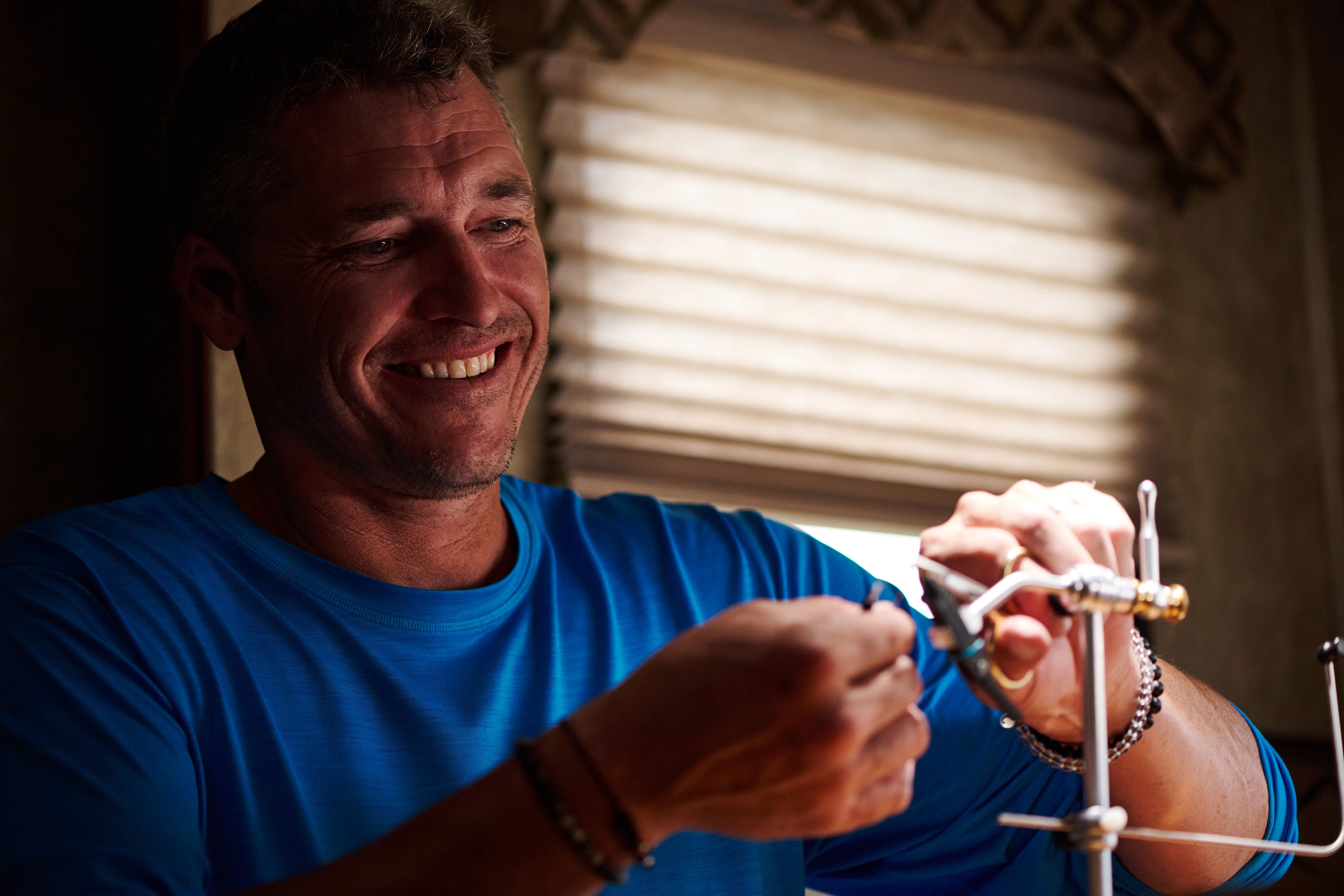 CHRIS HEUBLEIN working with fishing line inside his RV