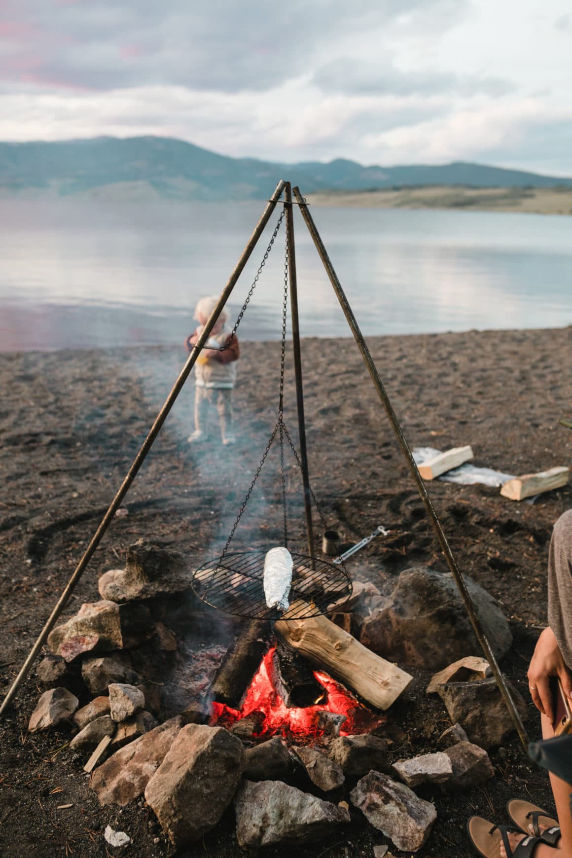 Campfire on beach cooking trout wrapped in foil