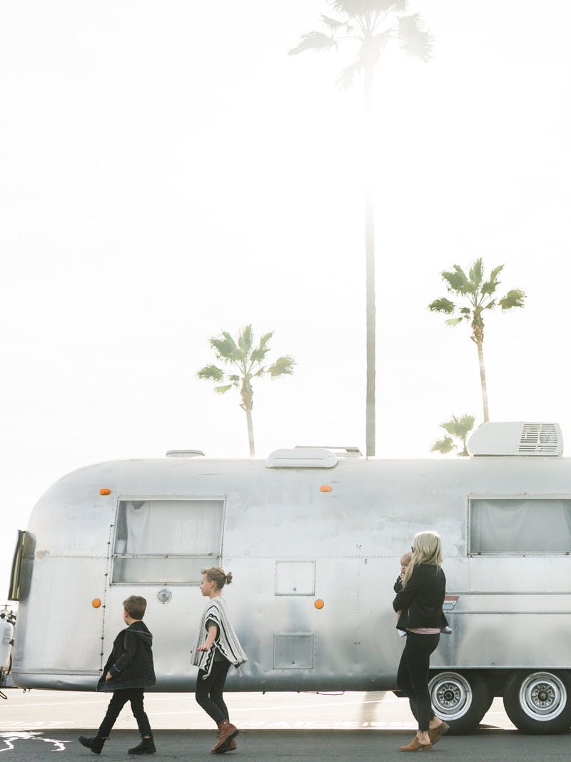 Amber thrane and her children walking in front of an Airstream RV.
