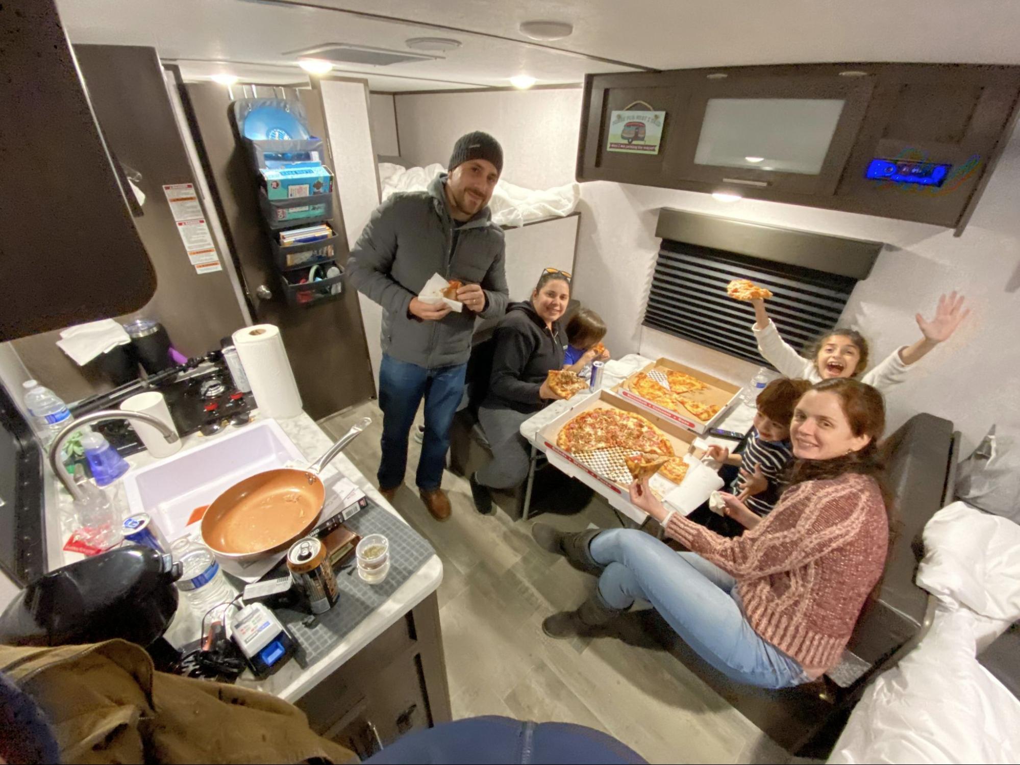 Juan and Johana Oropeza's friends eat pizza inside their RV