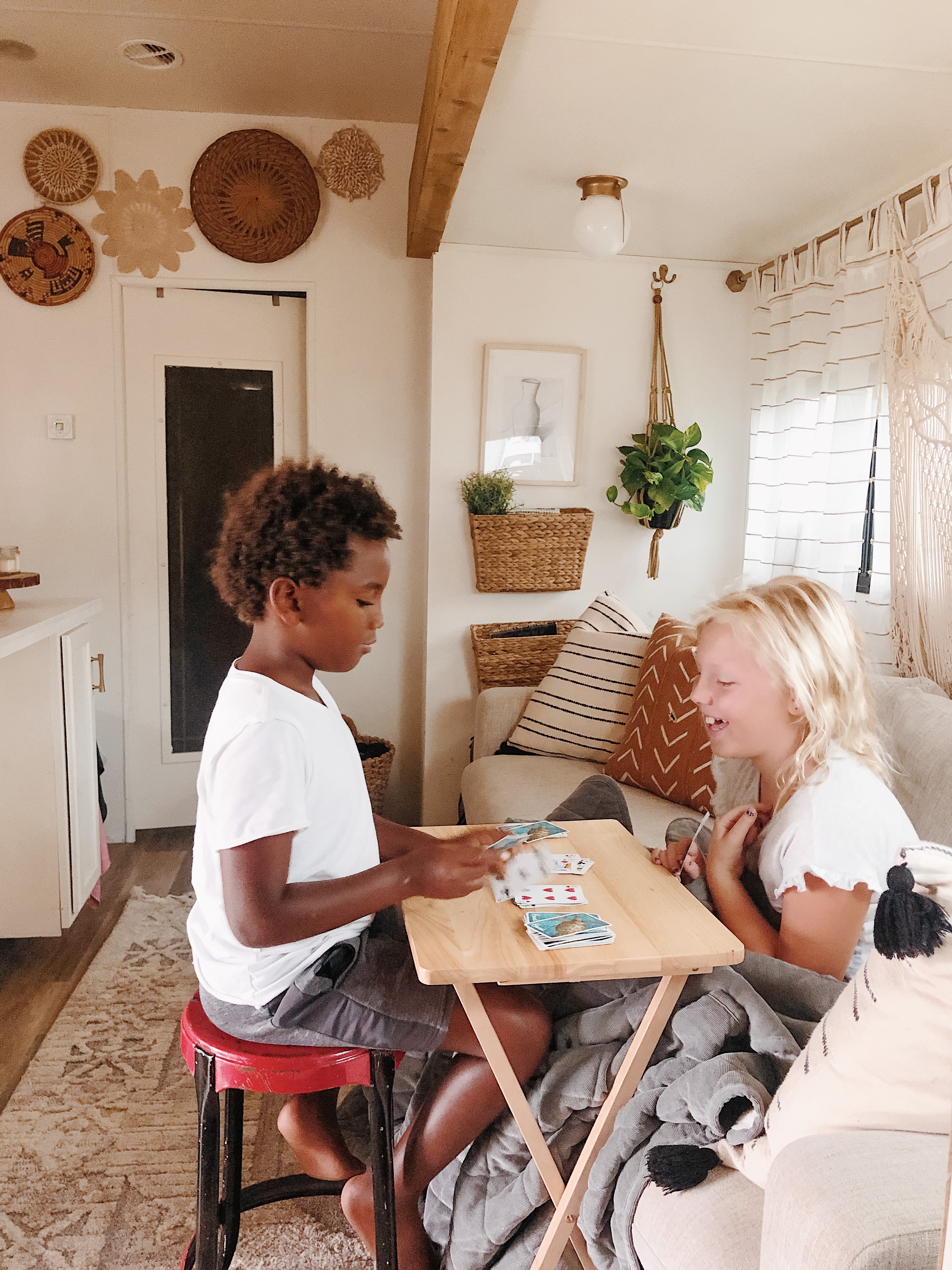 Shannon Carew's children play card games together inside their Highland Ridge RV.
