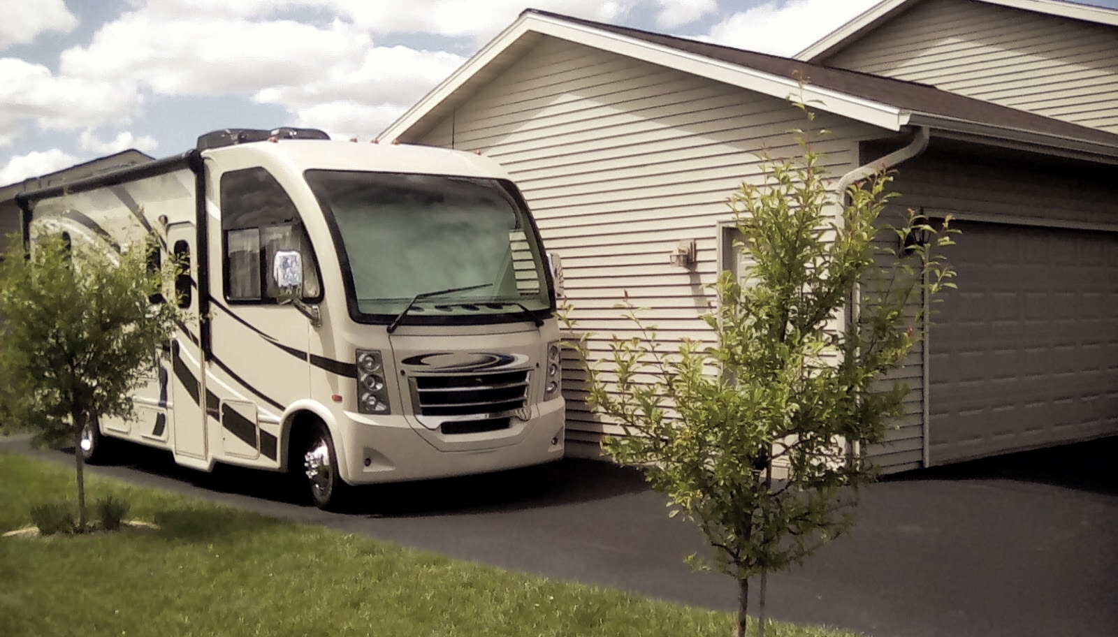 A Thor RV parked in a driveway next to the Bolands' house. 