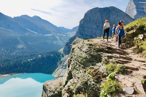A family hiking a rocky path in idyllic Glacier National Park.