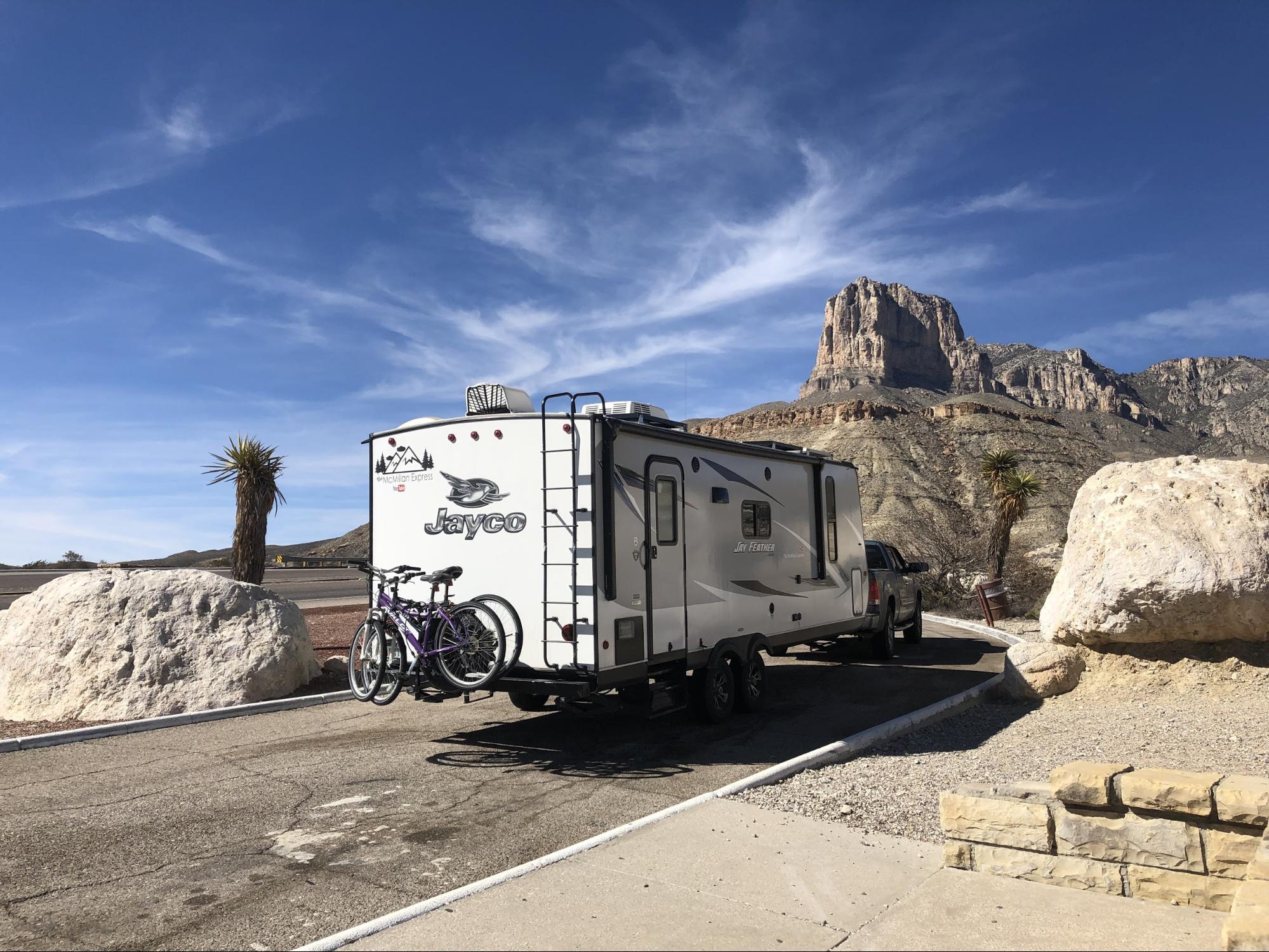 Ben and Christina McMillan's Jayco Jay Feather driving down the road near large rocks traveling from Texas to New Mexico.
