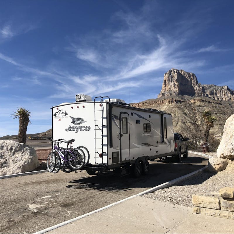 Ben and Christina McMillan's Jayco Jay Feather driving down the road near large rocks traveling from Texas to New Mexico.