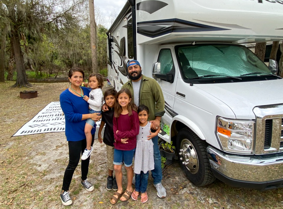 Sandra Peña's family of six poses for a photo in front of their Jayco Class C RV.