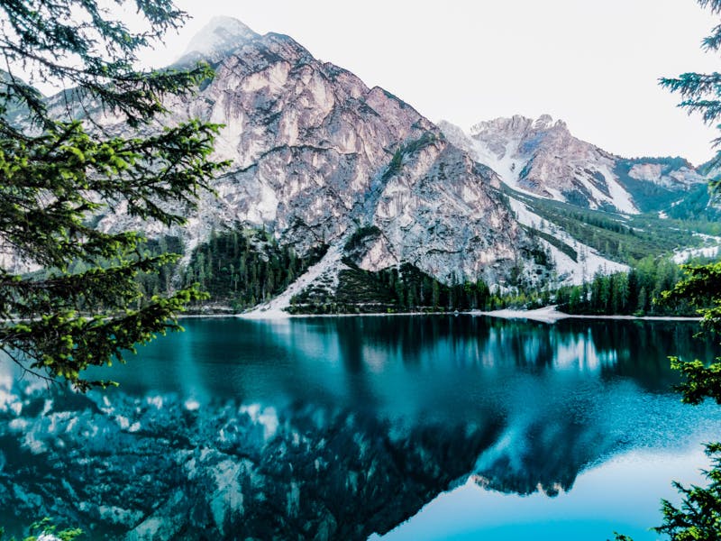 snowy mountain reflects into glassy water 