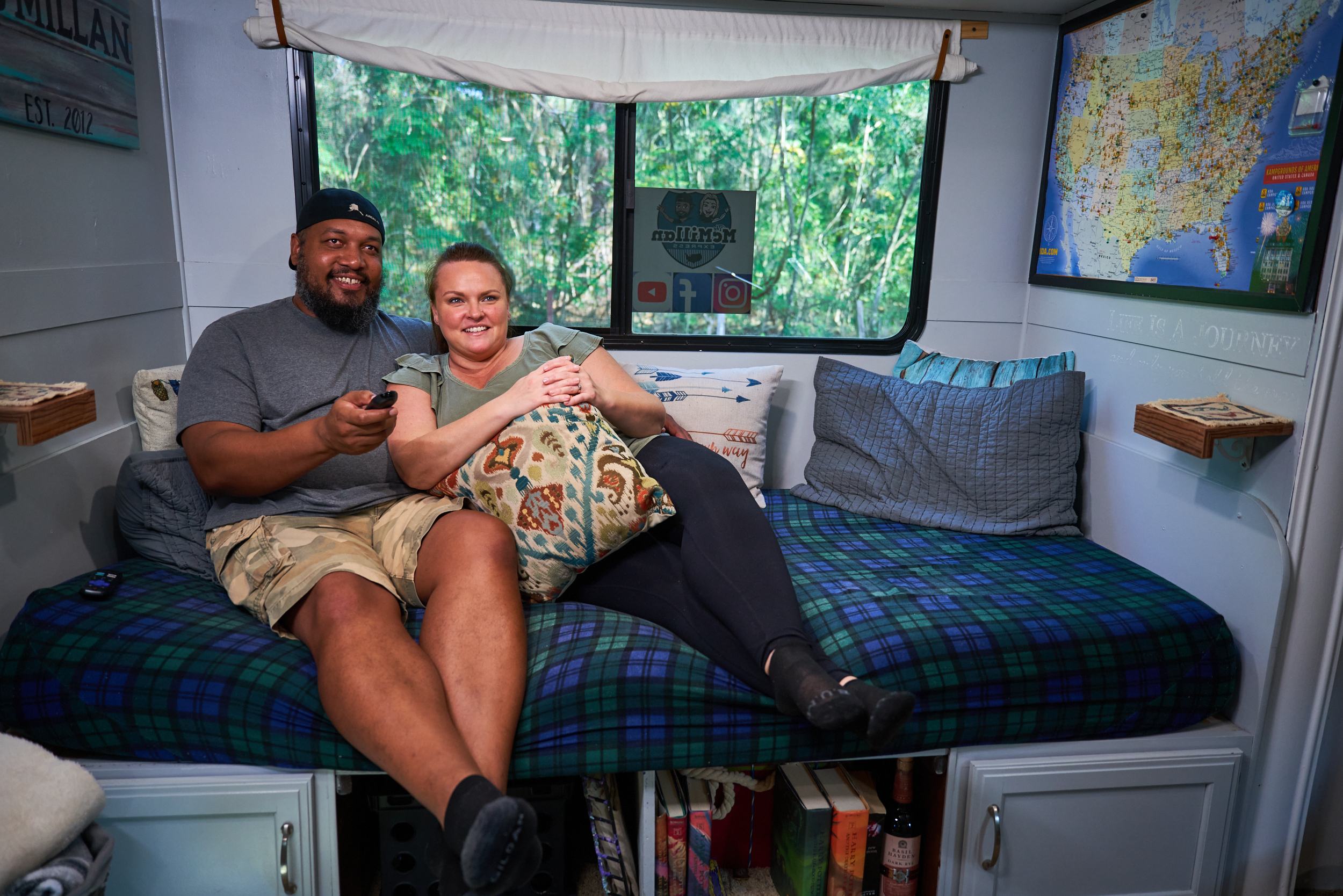 Ben and Christina McMillan lounging inside their RV watching TV