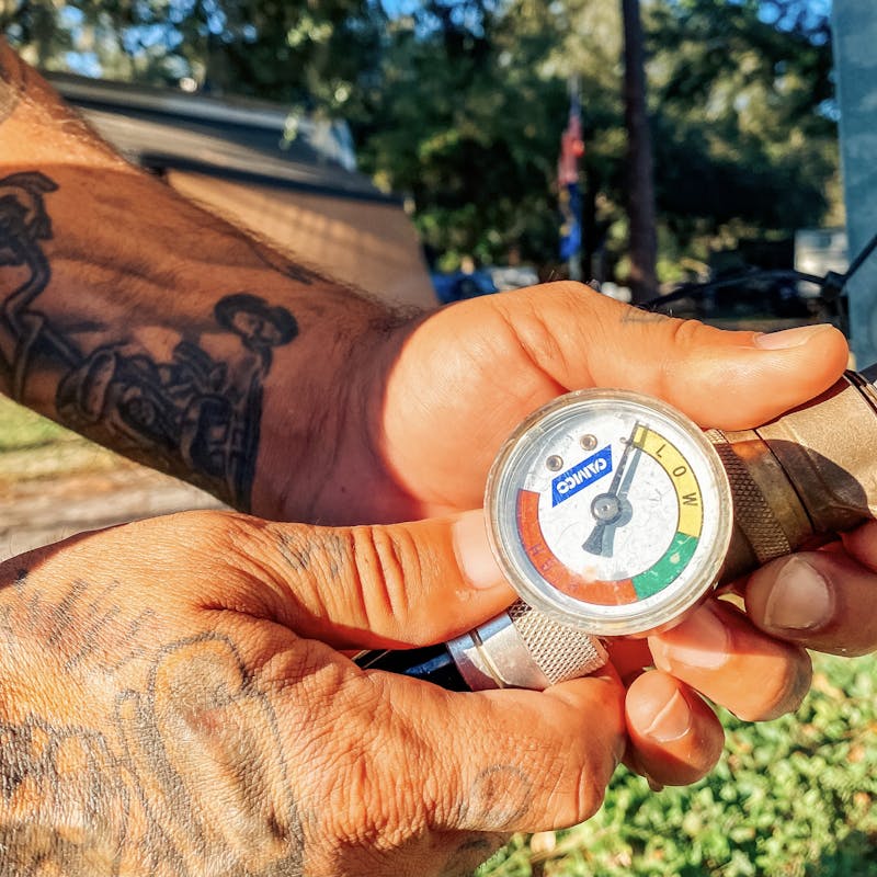 Justin Russel checking a pressure gauge.