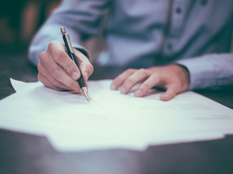 Man writing on paper in office