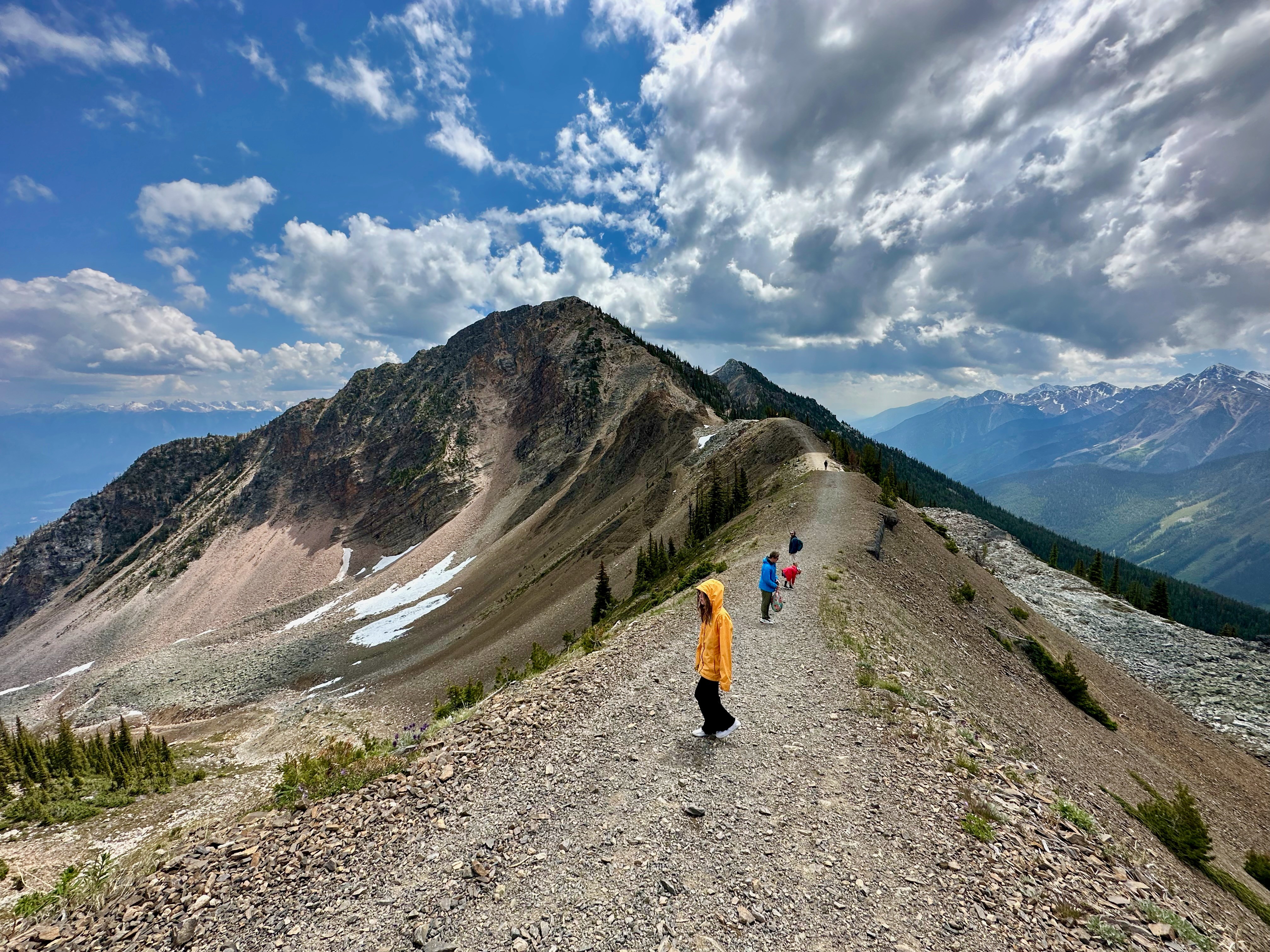 The Melissa and Lucas Lahr family hike along a gravel path in the mountains.
