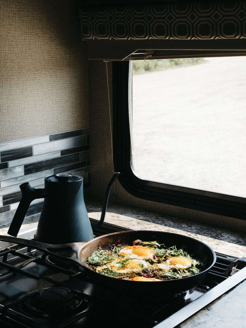 Skillet filled with swiss chard and pesto shakshuka in the RV kitchen. 